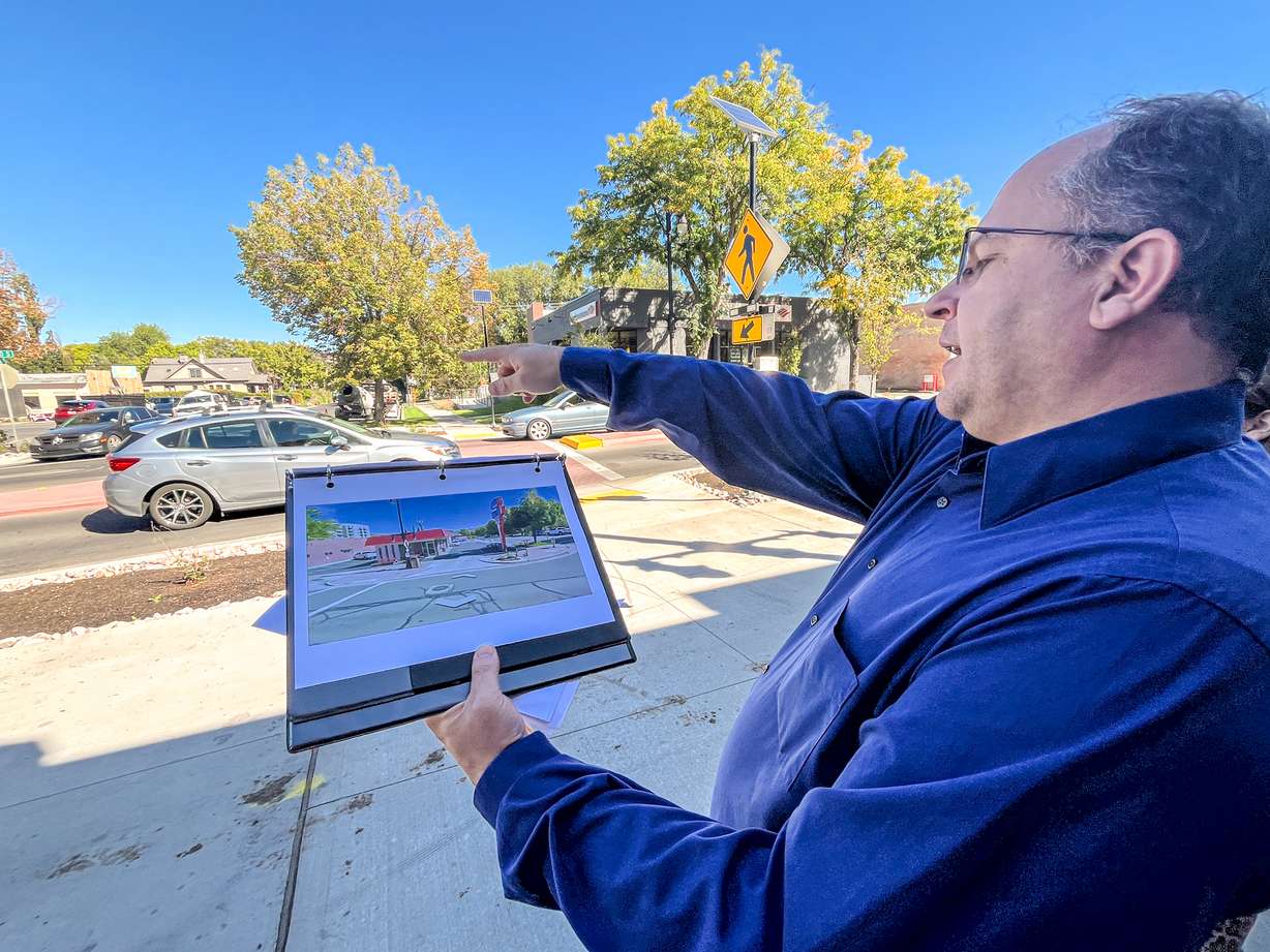 Lynn Jacobs, a project manager for Salt Lake City, points to a change on 2100 South near Millie's Burgers that was implemented based on feedback from the business during a tour of the changes in Salt Lake City's Sugar House neighborhood on Thursday. The project, he said, shifted a few times from business and motorist feedback.