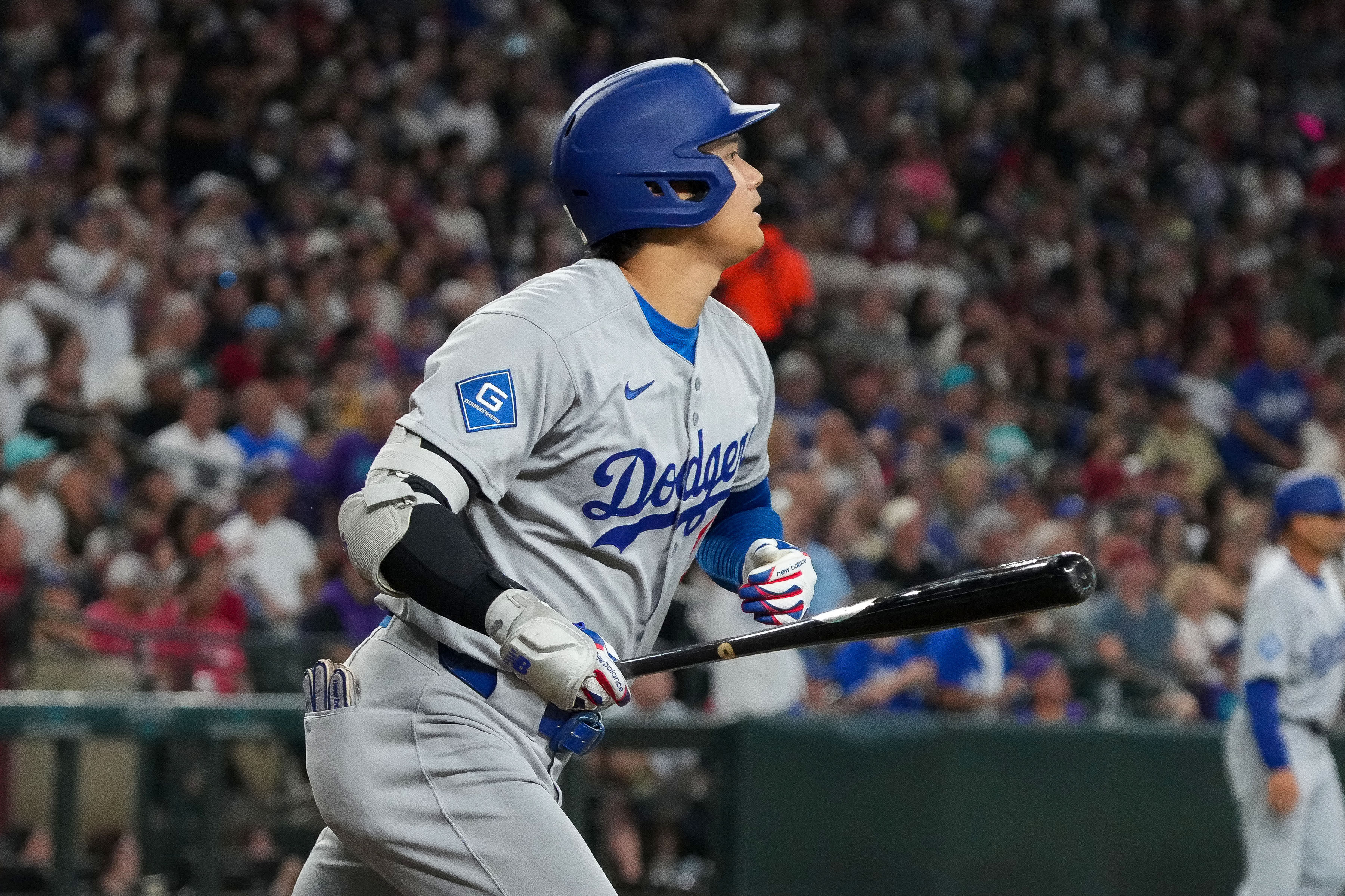 Los Angeles Dodgers' Shohei Ohtani watches his home run during the fourth inning of a baseball game against the Arizona Diamondbacks, Thursday, Sept. 25, 2025, in Phoenix. 