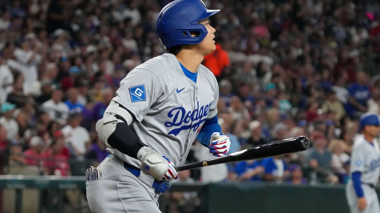 Los Angeles Dodgers' Shohei Ohtani watches his home run during the fourth inning of a baseball game against the Arizona Diamondbacks, Thursday, Sept. 25, 2025, in Phoenix.