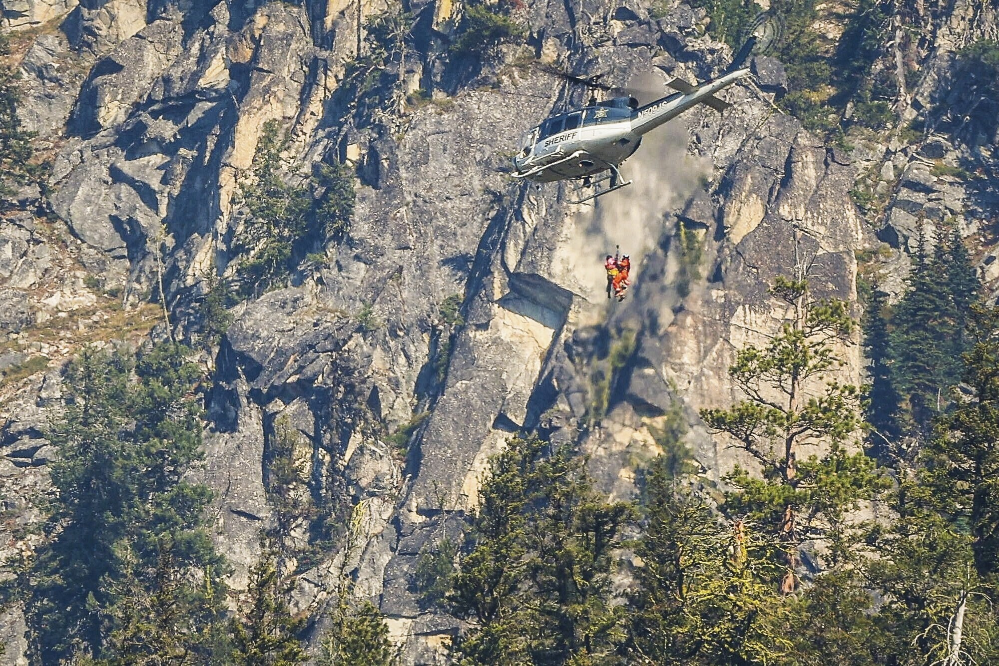 Authorities rappel from a helicopter to the site of human remains near Grindstone Mountain, Friday, near Leavenworth, Wash. DNA tests confirmed Thursday the remains were Travis Decker's, who was wanted in the killing of his daughters.