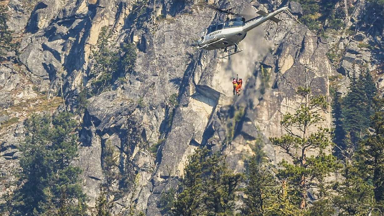Authorities rappel from a helicopter to the site of human remains near Grindstone Mountain, Friday, near Leavenworth, Wash. DNA tests confirmed Thursday the remains were Travis Decker's, who was wanted in the killing of his daughters.