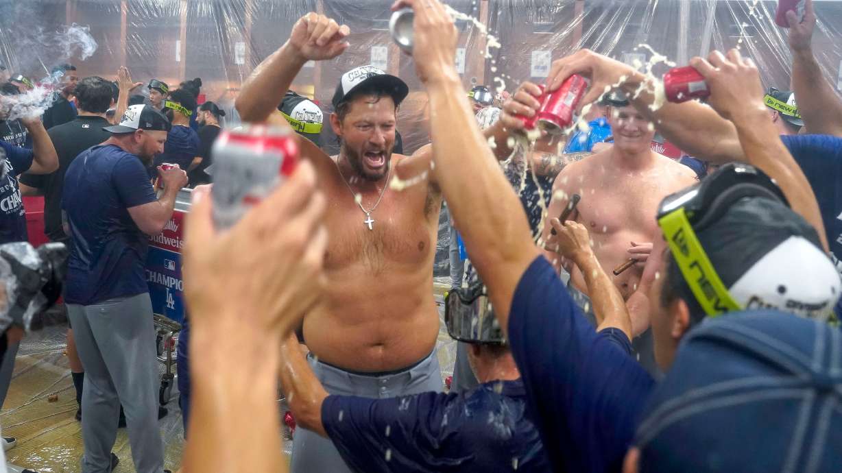 Los Angeles Dodgers pitcher Clayton Kershaw, center, celebrates with his teammates after the Dodgers clinched the National League West title against the Arizona Diamondbacks during a baseball game at Chase Field Thursday, Sept. 25, 2025, in Phoenix.