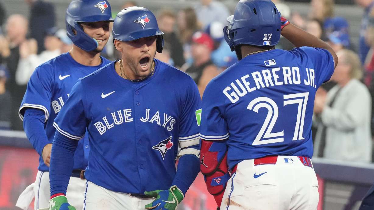 Toronto Blue Jays' George Springer (centre) celebrates his two-run home run against the Boston Red Sox with Vladimir Guerrero Jr. (27) during sixth inning MLB baseball action in Toronto on Thursday Sept. 25, 2025.