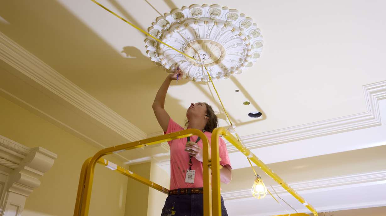 An artist paints a ceiling medallion in the council room hallway of the Salt Lake Temple on Sept. 10. Church officials said Friday that painting and finish work has been completed within many of the temple's sacred rooms.