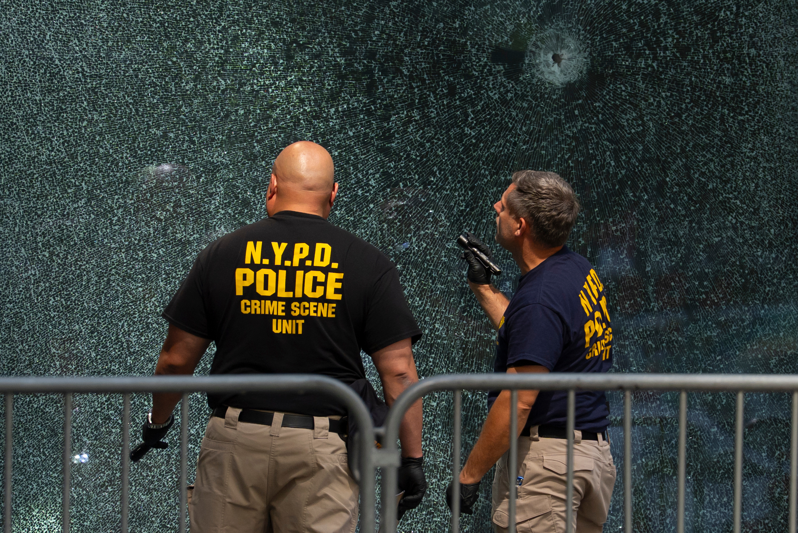 FILE - Members of the NYPD's Crime Scene Unit examine a door with bullet holes, Tuesday, July 29, 2025, in New York, the day after a deadly shooting.