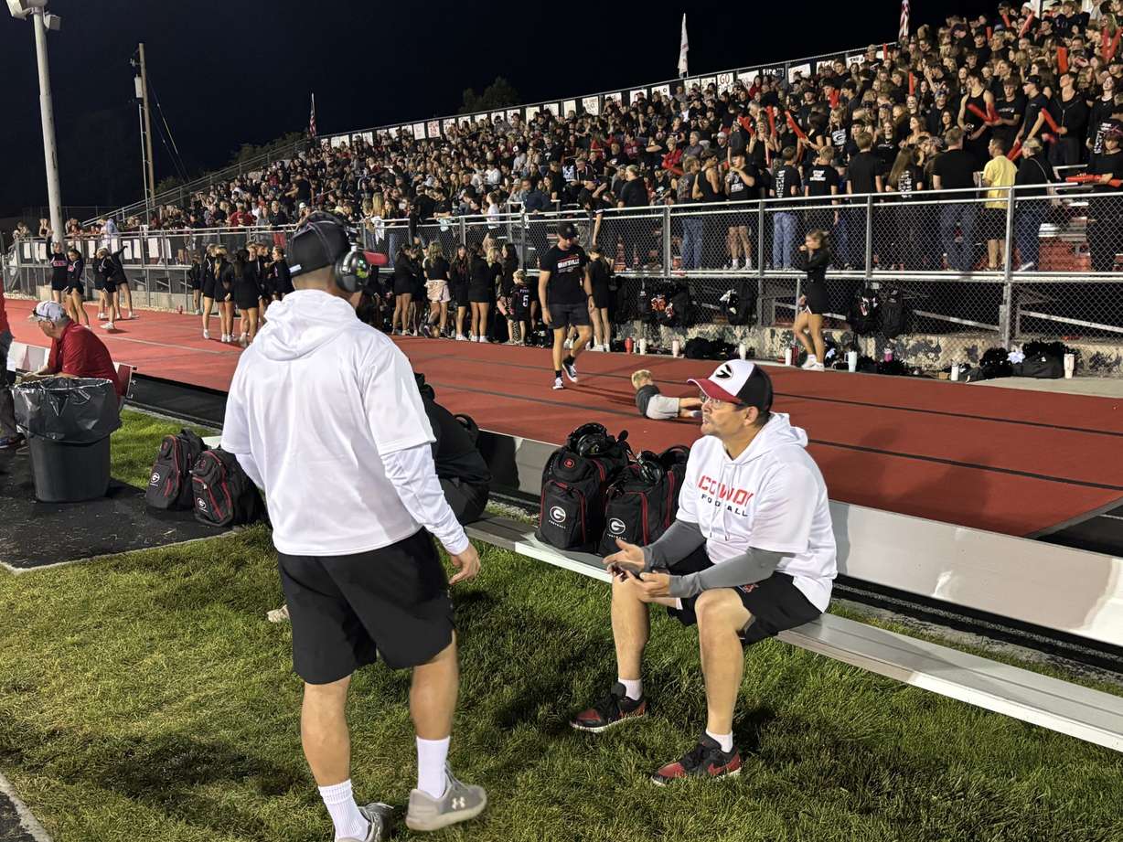 Scott and Alan Mouritsen chat on the sideline during Grantsville's homecoming game.