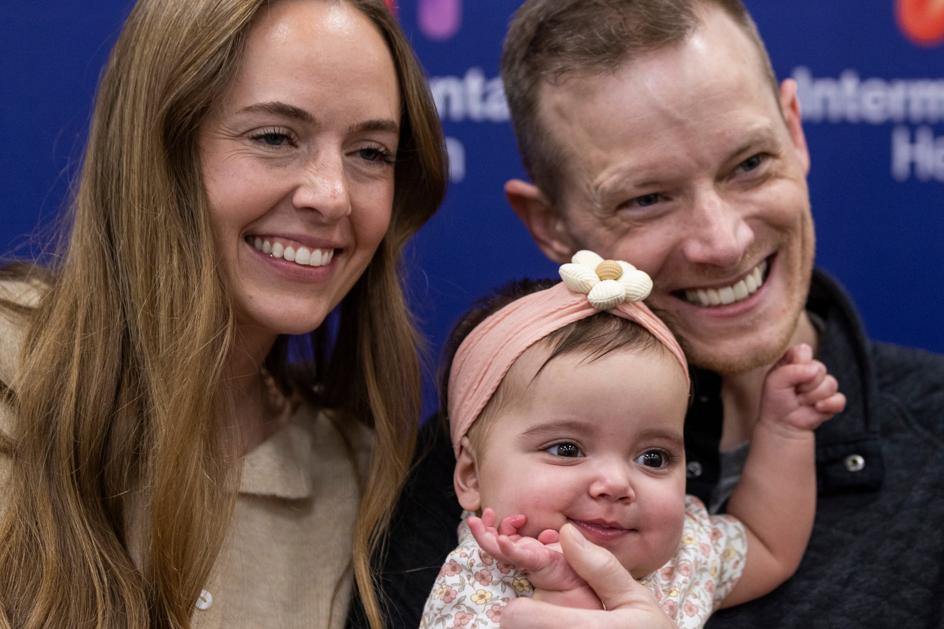 Annie Larrabee, left, poses for a photo with the recipient of her liver, 9-month-old Elieanna Tibbs, and Tibbs’ father and fellow liver donor Justin, right, during a media event for Utah's first pediatric paired liver exchange at Intermountain Primary Children’s Hospital in Salt Lake City on Friday.