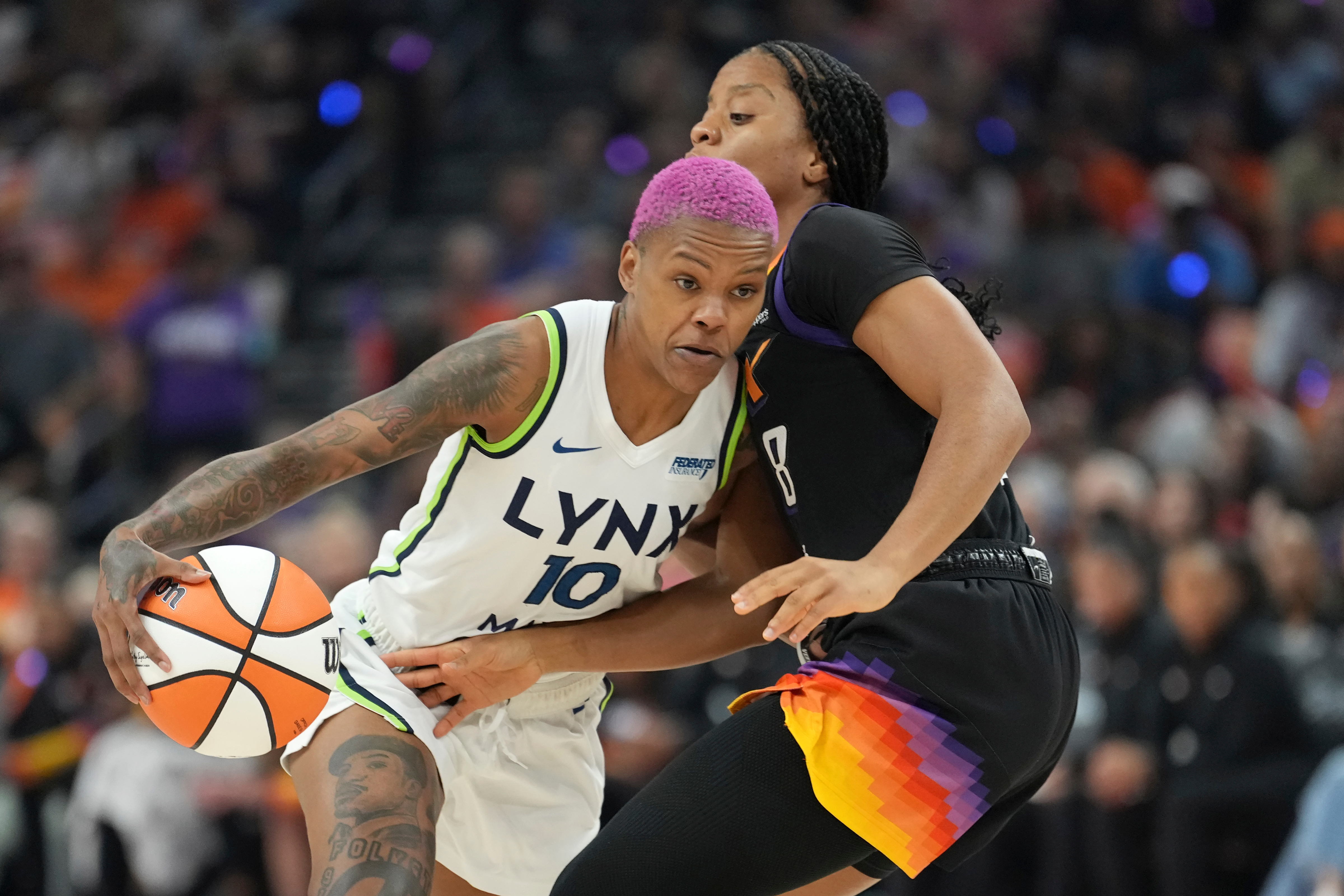 Minnesota Lynx guard Courtney Williams (10) dribbles past Phoenix Mercury guard Monique Akoa Makani (8) during the first half of Game 3 of a WNBA basketball playoff semifinals series game Friday, Sept. 26, 2025, in Phoenix. 