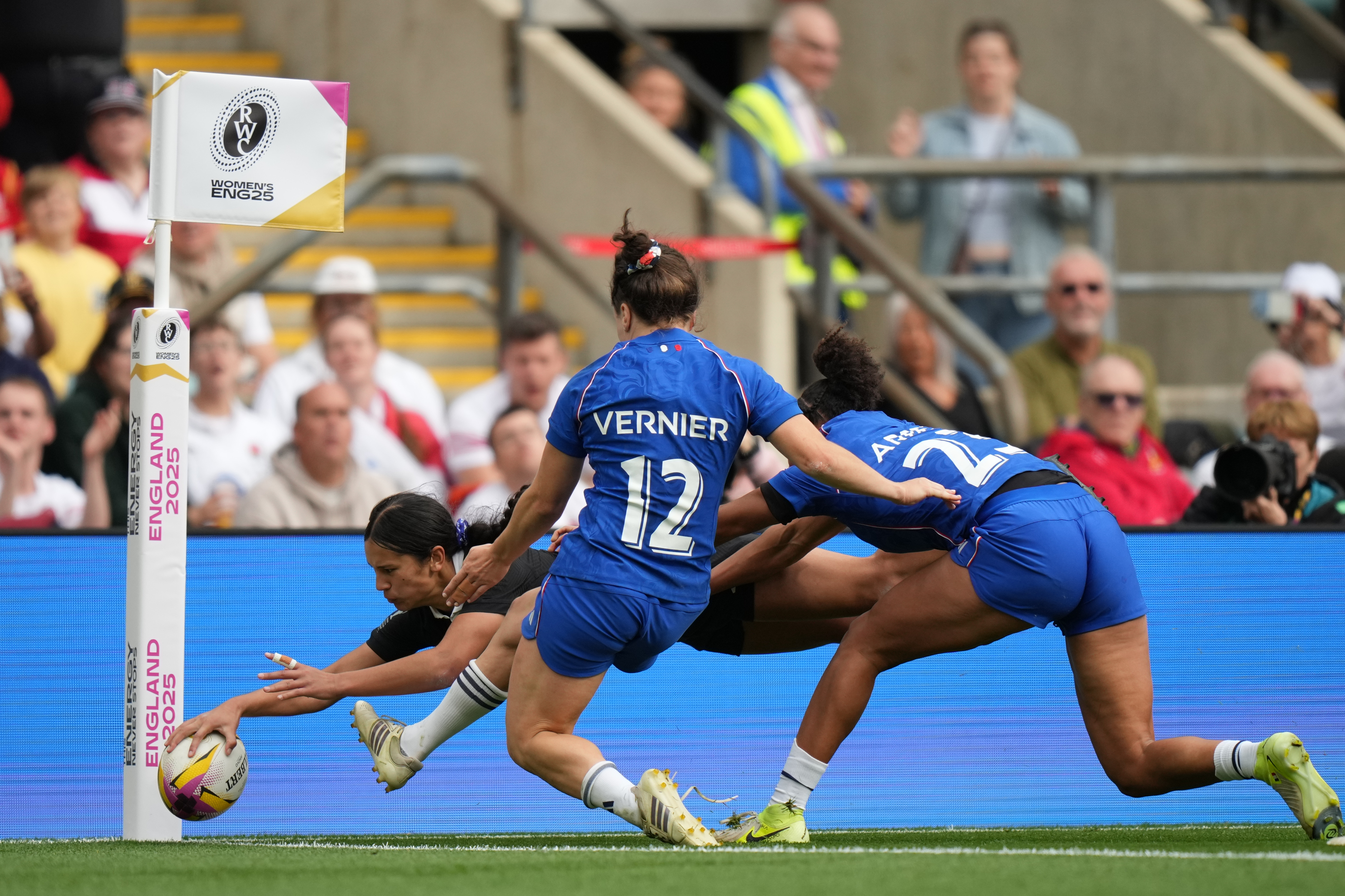 New Zealand's Braxton Sorensen-McGee, left, scores a try past Gaby Vernier of France, center and Kelly Arbey of France, right, during the Women's Rugby World Cup bronze match between New Zealand and France at the Allianz Stadium, Twickenham, London, Saturday, Sept. 27, 2025. 