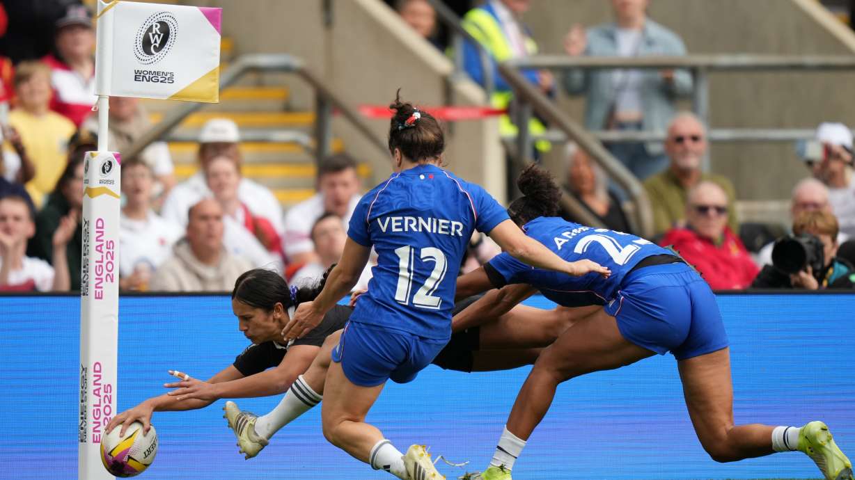 New Zealand's Braxton Sorensen-McGee, left, scores a try past Gaby Vernier of France, center and Kelly Arbey of France, right, during the Women's Rugby World Cup bronze match between New Zealand and France at the Allianz Stadium, Twickenham, London, Saturday, Sept. 27, 2025.