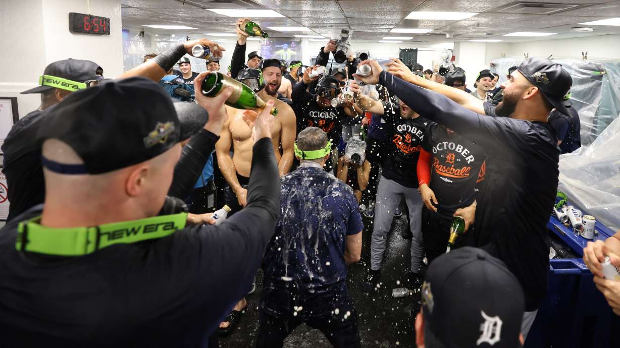 The Detroit Tigers celebrate in the locker room after defeating the Boston Red Sox and clinching a spot in the playoffs, Saturday, Sept. 27, 2025, in Boston.