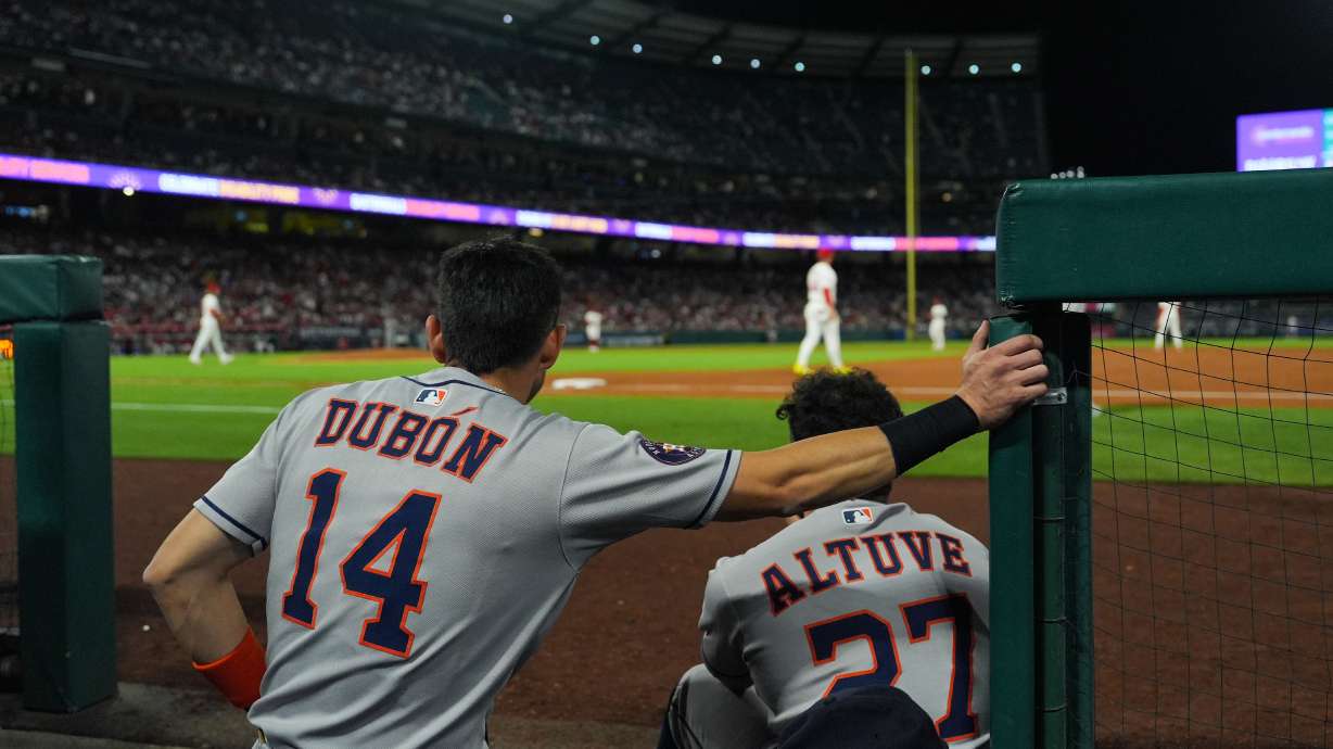 Houston Astros' Mauricio Dubon (14) and Jose Altuve (27) watch from the dugout during the third inning of a baseball game against the Los Angeles Angels Saturday, Sept. 27, 2025, in Anaheim, Calif.