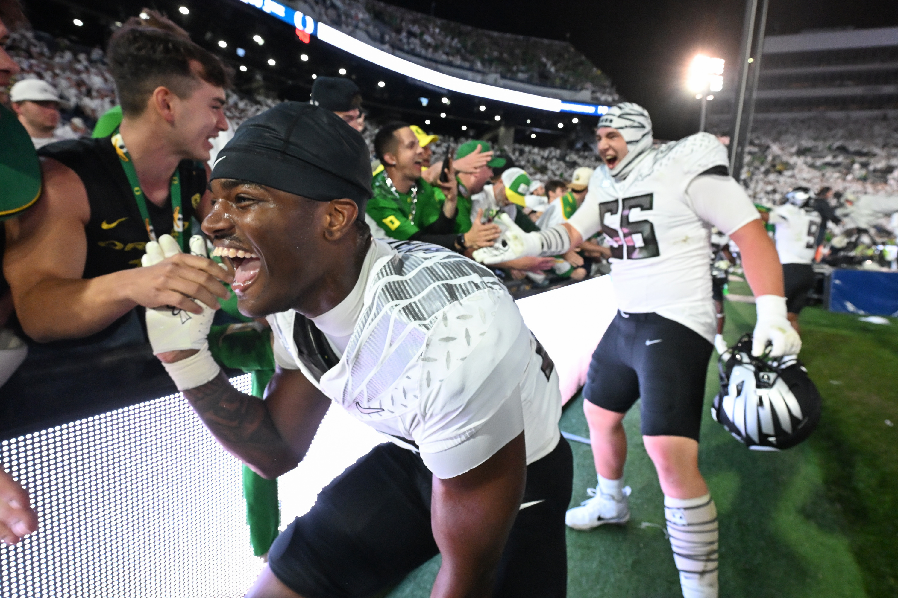 Oregon linebacker Nasir Wyatt (32) and Oregon offensive lineman Trent Ferguson (56) celebrate their second overtime win over Penn State during their NCAA college football game, Saturday, Sept. 27, 2025, in State College, Pa. 
