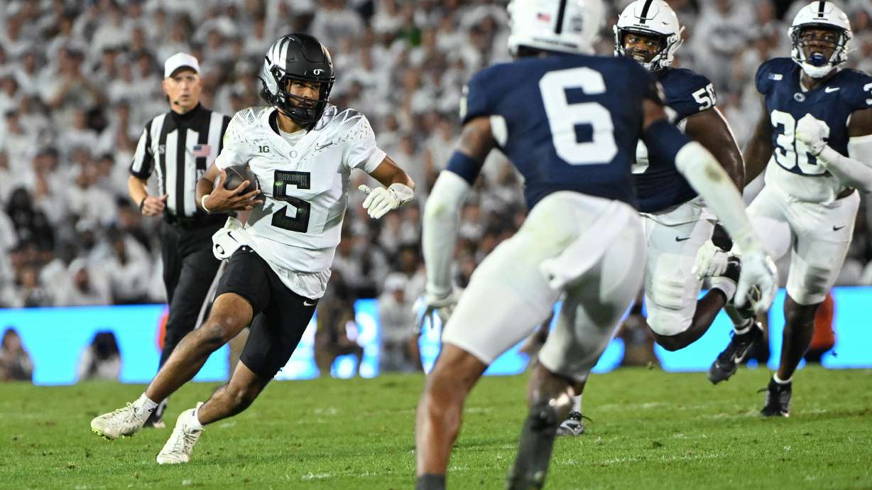 Oregon quarterback Dante Moore (5) looks to elude Penn State safety Zakee Wheatley (6) during the first quarter of an NCAA college football game, Saturday, Sept. 27, 2025, in State College, Pa.