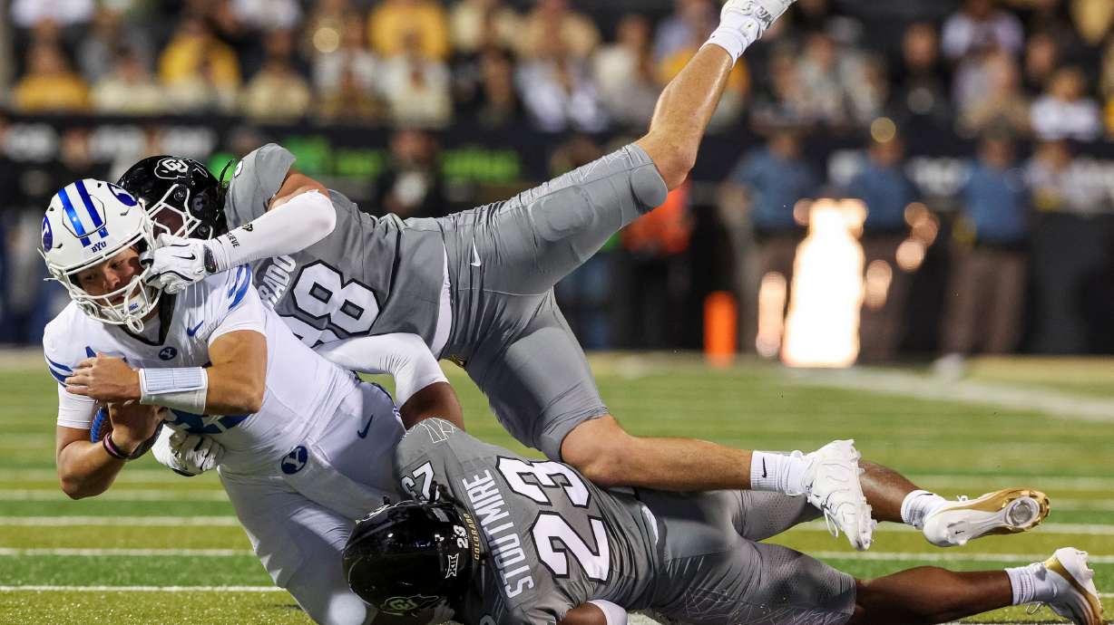 BYU Cougars quarterback Bear Bachmeier (47) is tackled by Colorado defensive end Alexander McPherson (98) and safety Carter Stoutmire (23) during the first half of the game at Folsom Field in Boulder, Colo., on Saturday, Sept. 27, 2025.