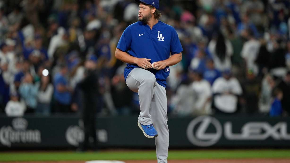Los Angeles Dodgers starting pitcher Clayton Kershaw pretends to throw on the mound after the team's win in a baseball game against the Seattle Mariners, Friday, Sept. 26, 2025, in Seattle.