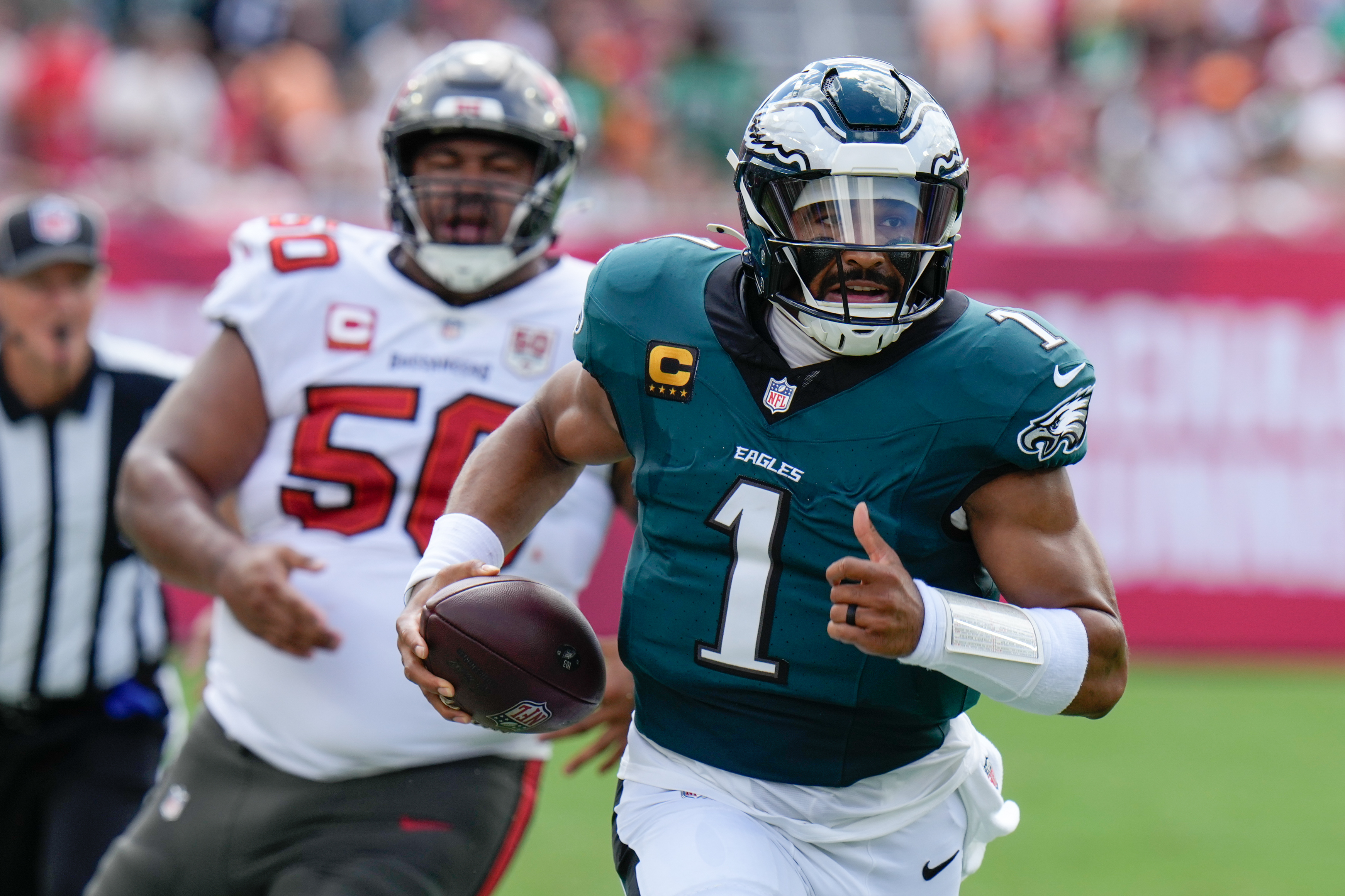 Philadelphia Eagles quarterback Jalen Hurts (1) runs the ball for a first down during the first half of an NFL football game against the Tampa Bay Buccaneers, Sunday, Sept. 28, 2025, in Tampa, Fla. 