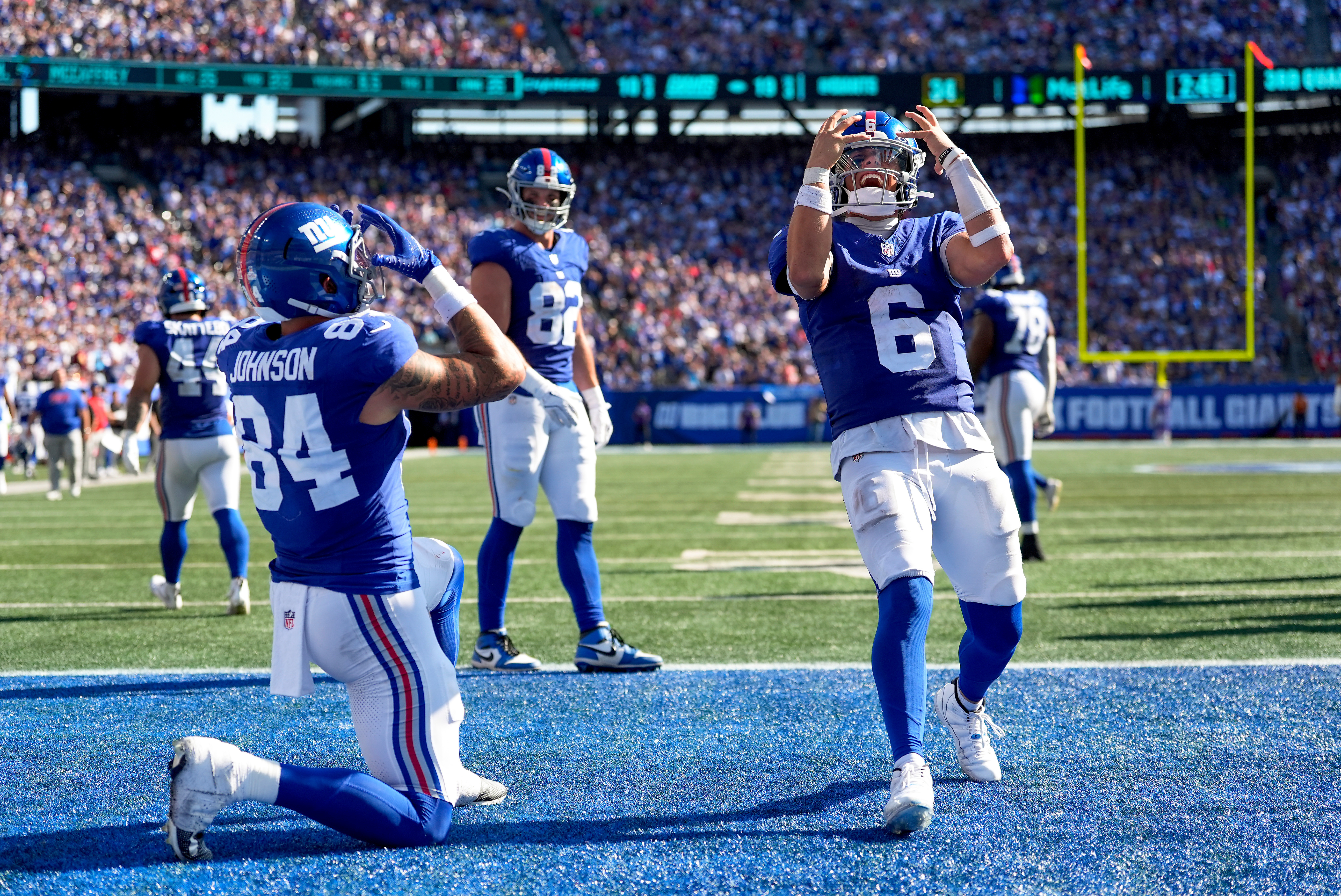 New York Giants tight end Theo Johnson (84) and quarterback Jaxson Dart (6) celebrate after Johnson scored a touchdown against the Los Angeles Chargers during the third quarter of an NFL football game, Sunday, Sept. 28, 2025, in East Rutherford, N.J. 