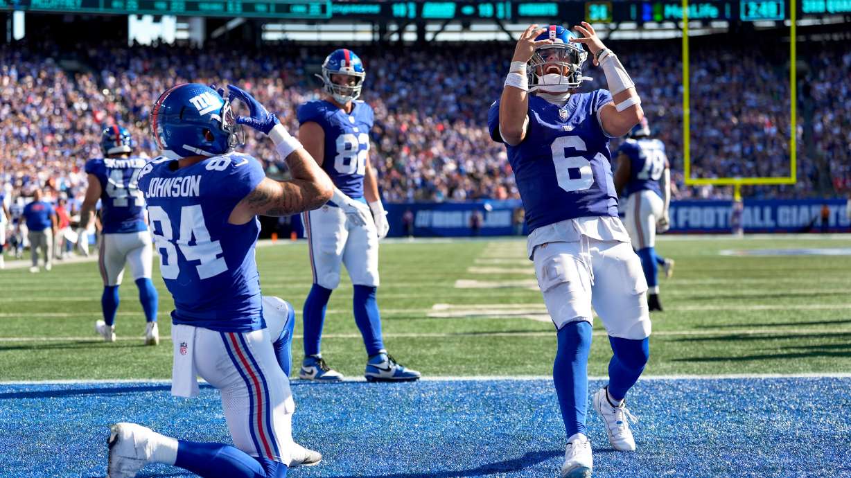 New York Giants tight end Theo Johnson (84) and quarterback Jaxson Dart (6) celebrate after Johnson scored a touchdown against the Los Angeles Chargers during the third quarter of an NFL football game, Sunday, Sept. 28, 2025, in East Rutherford, N.J.