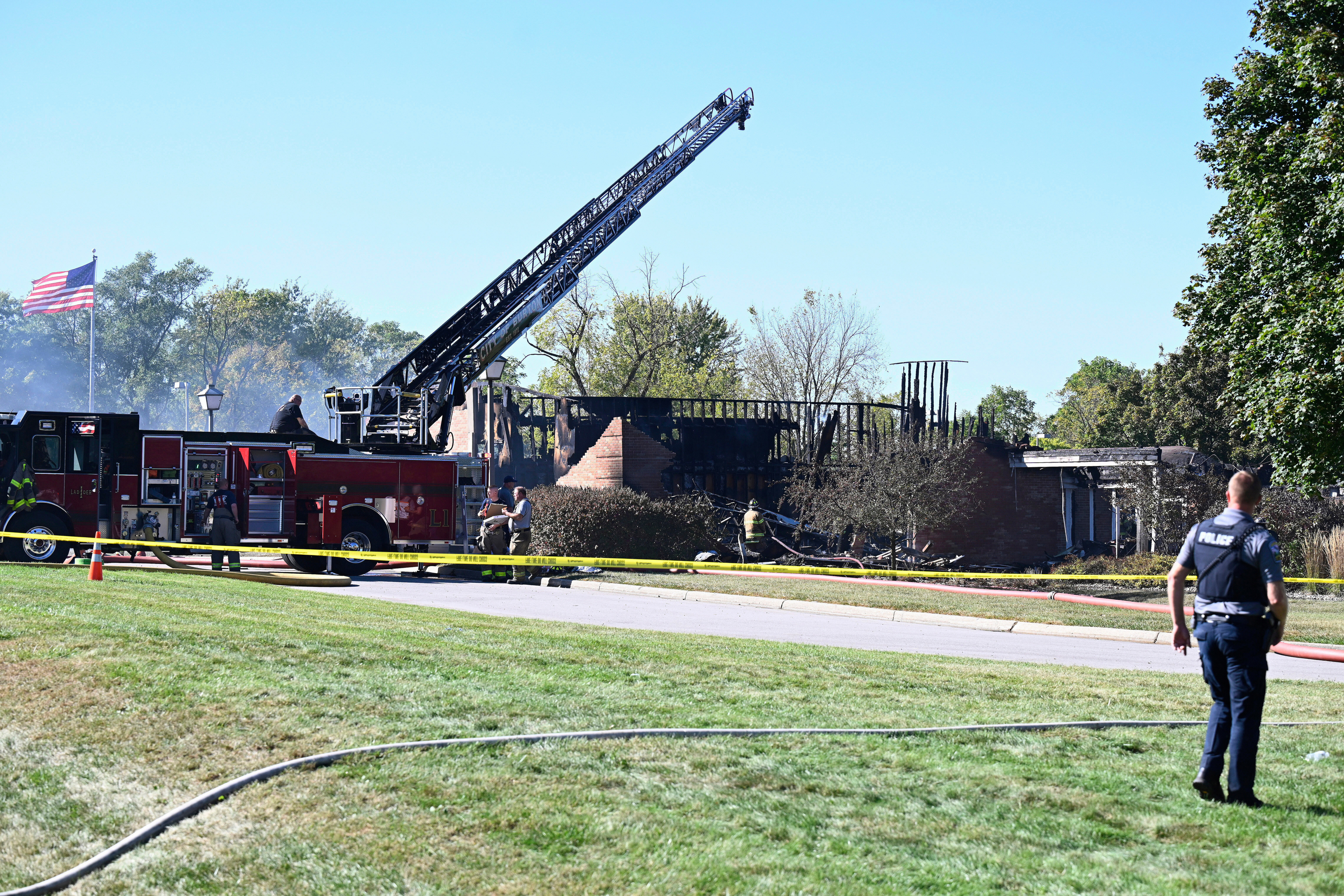 Law enforcement guard the area where a shooting and fire took place at The Church of Jesus Christ of Latter-day Saints meetinghouse, Sunday in Grand Blanc, Mich.