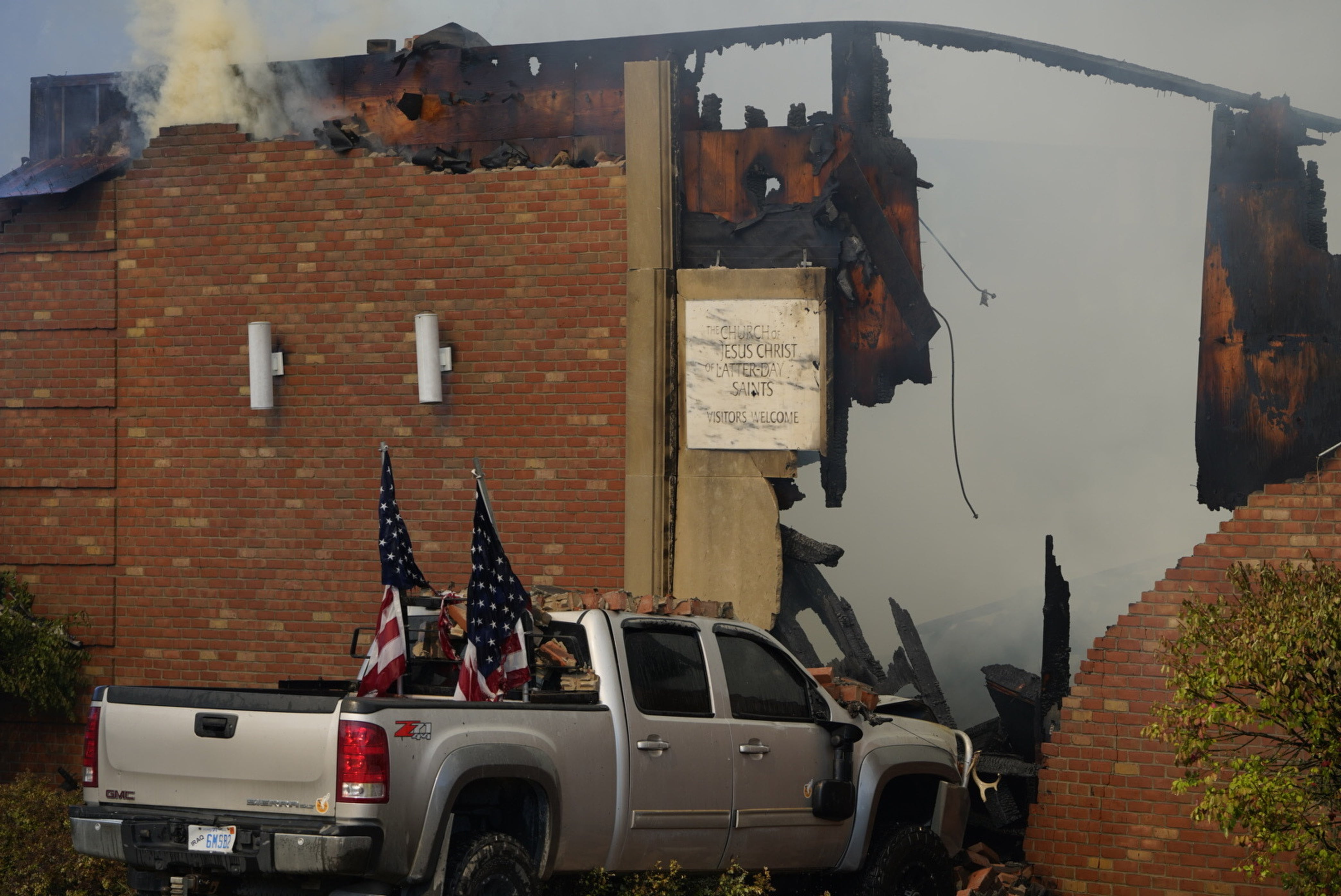A vehicle rammed into the building is surrounded by smoke, at a meetinghouse of The Church of Jesus Christ of Latter-day Saints in Grand Blanc, Mich., on Sunday.