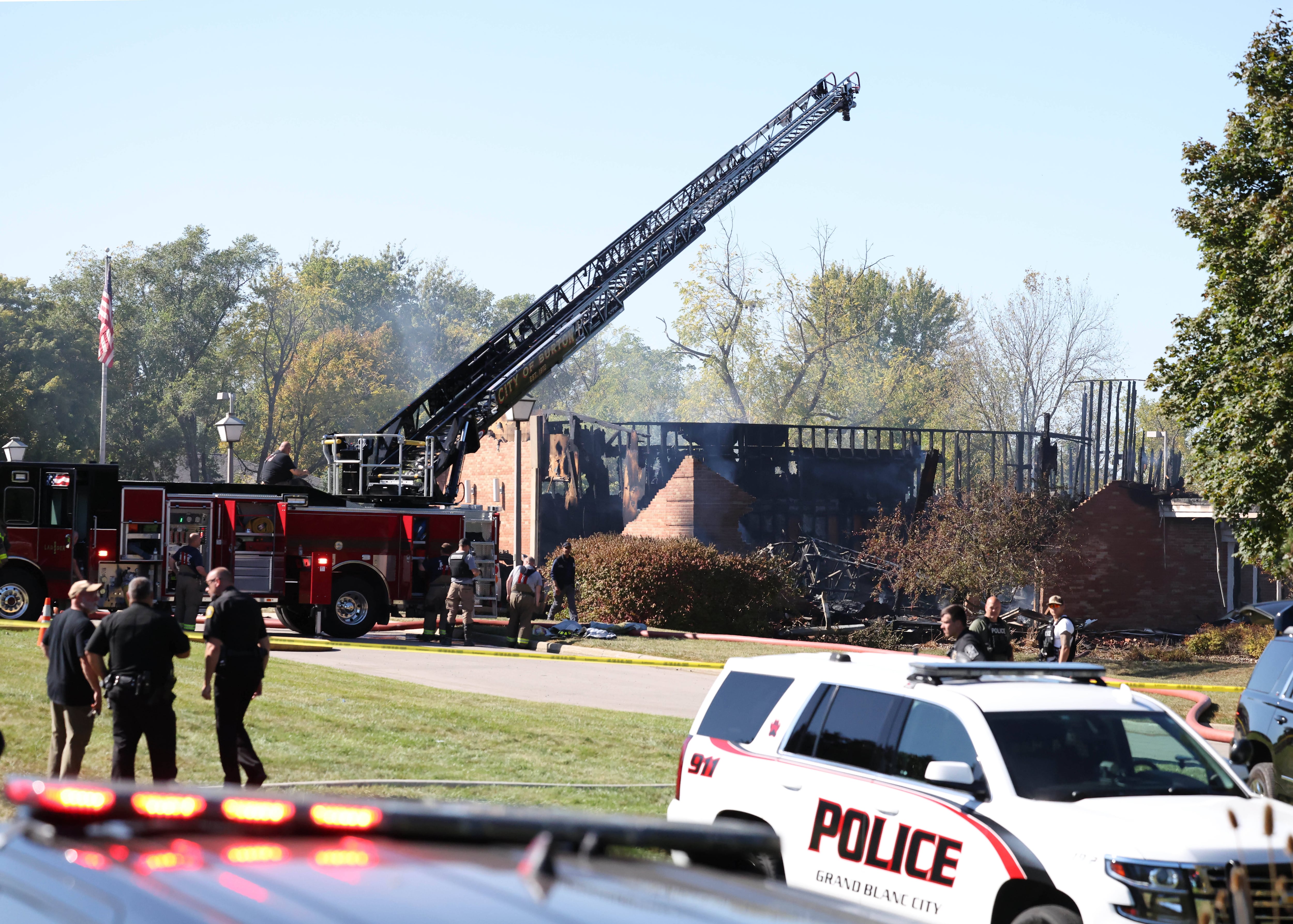 Fire and law enforcement officers stand outside a meetinghouse of The Church of Jesus Christ of Latter-day Saints on Sunday in Grand Blanc Township, Mich.