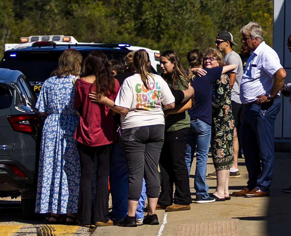 Family and friends wait outside a movie theater to be reunited with family members after a shooting and fire at a meetinghouse of The Church of Jesus Christ of Latter-day Saints in Grand Blanc Township, Michigan, on Sunday.