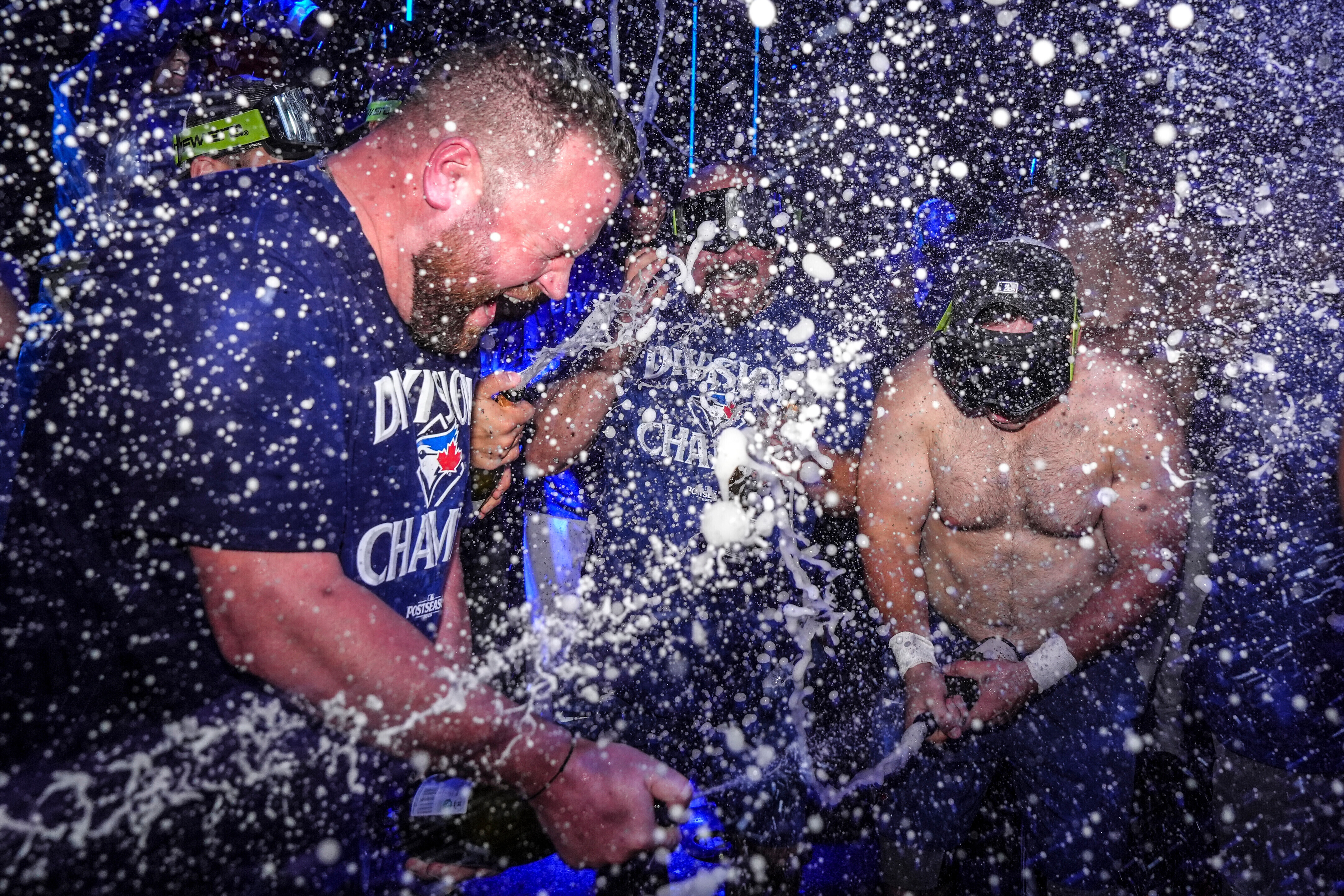 Toronto Blue Jays manager John Schneider, left, joins in with the team to celebrate after winning the American League East Division title following MLB baseball action against the Tampa Bay Rays, in Toronto, Sunday, Sept. 28, 2025. 
