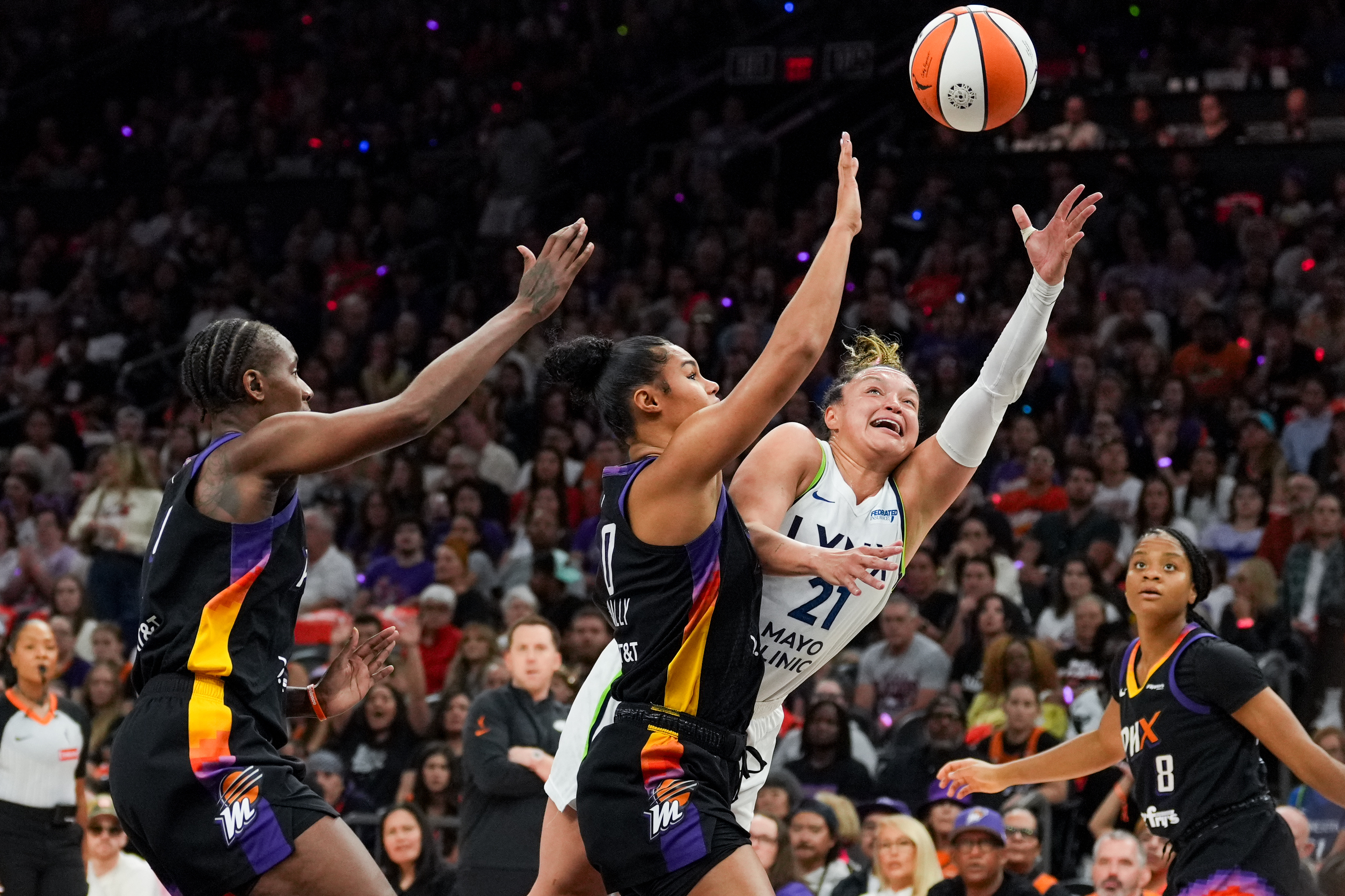 Phoenix Mercury forward Satou Sabally, center, fouls Minnesota Lynx guard Kayla McBride (21) during the first half of Game 4 of a WNBA basketball playoff semifinals series, Sunday, Sept. 28, 2025, in Phoenix. 