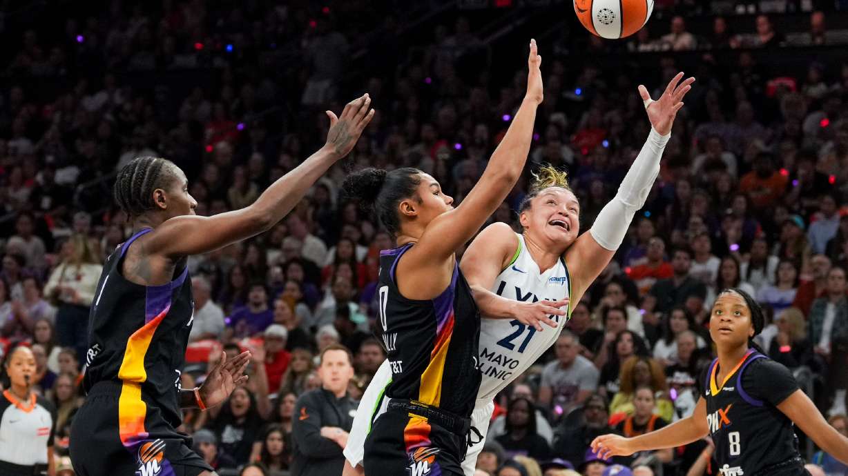 Phoenix Mercury forward Satou Sabally, center, fouls Minnesota Lynx guard Kayla McBride (21) during the first half of Game 4 of a WNBA basketball playoff semifinals series, Sunday, Sept. 28, 2025, in Phoenix.