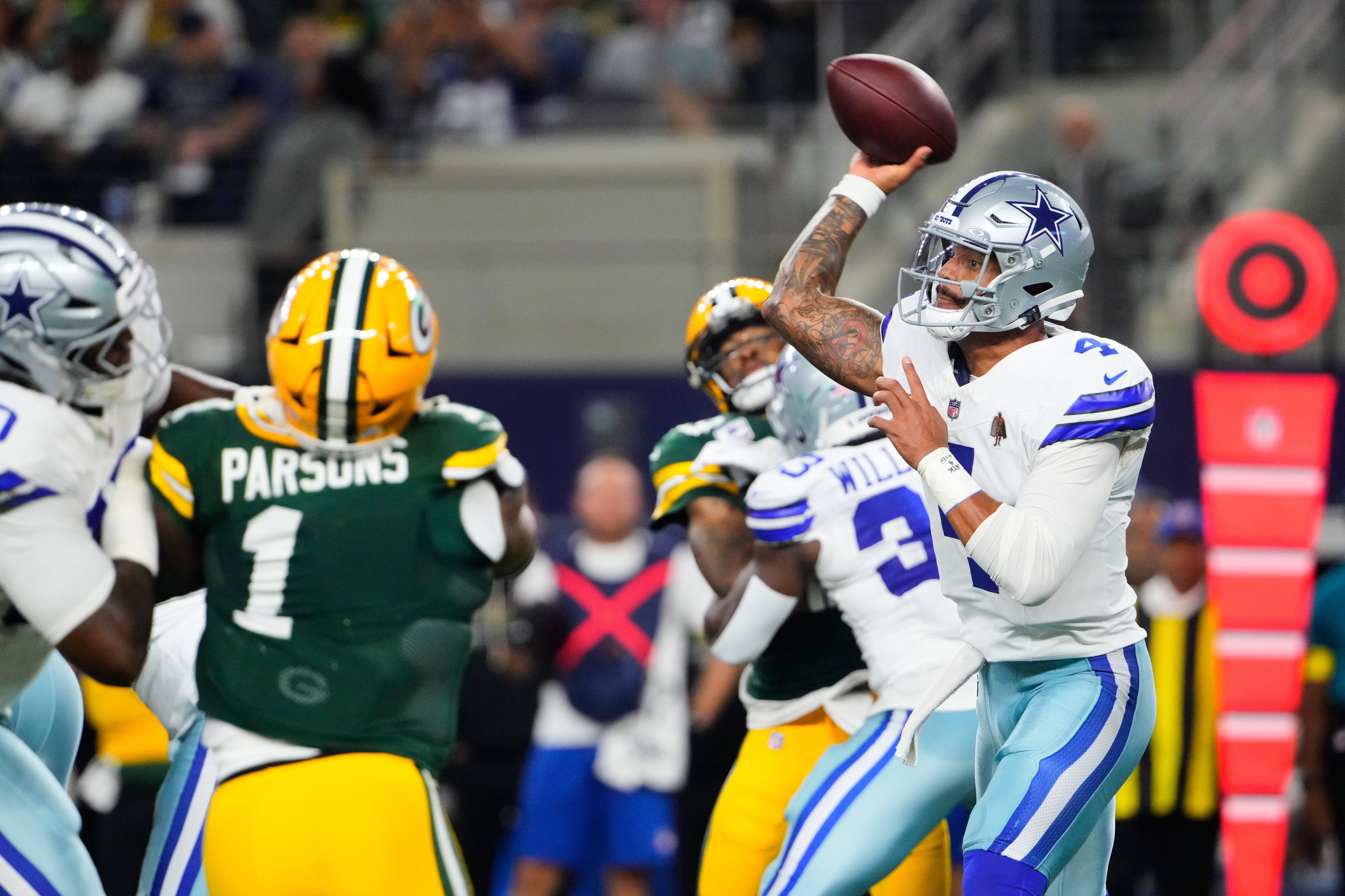 Dallas Cowboys quarterback Dak Prescott (4) throws a pass under pressure from Green Bay Packers defensive end Micah Parsons (1) in the first half of an NFL football game Sunday, Sept. 28, 2025, in Arlington, Texas.