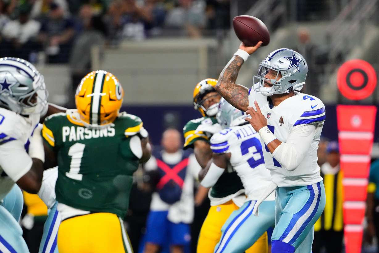 Dallas Cowboys quarterback Dak Prescott (4) throws a pass under pressure from Green Bay Packers defensive end Micah Parsons (1) in the first half of an NFL football game Sunday, Sept. 28, 2025, in Arlington, Texas.