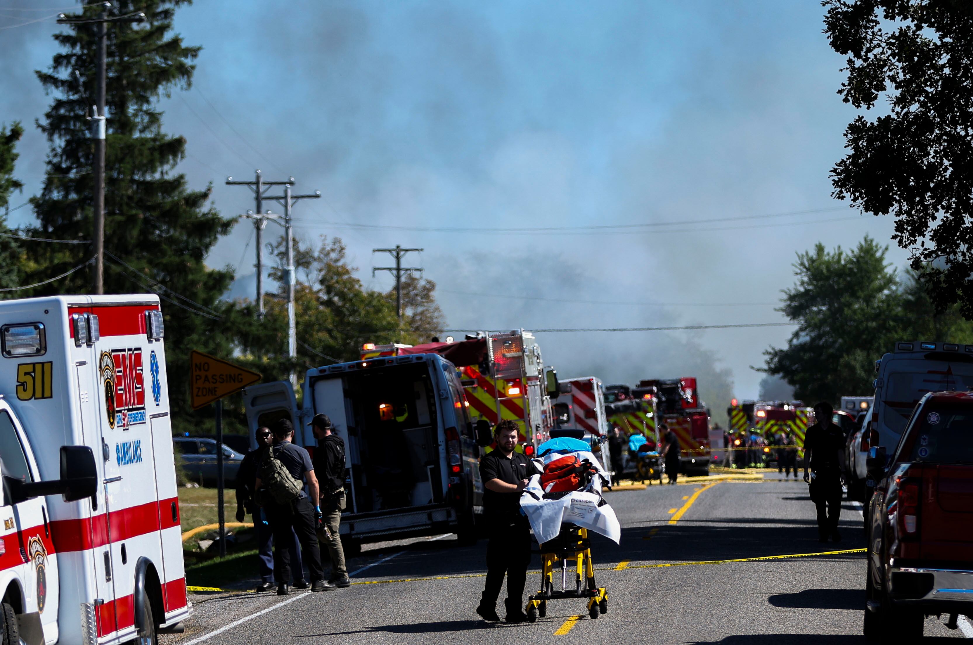 Law enforcement and emergency medical services stage outside of the scene of a shooting and fire at a meetinghouse of The Church of Jesus Christ of Latter-day Saints in Grand Blanc, Michigan, on Sunday.