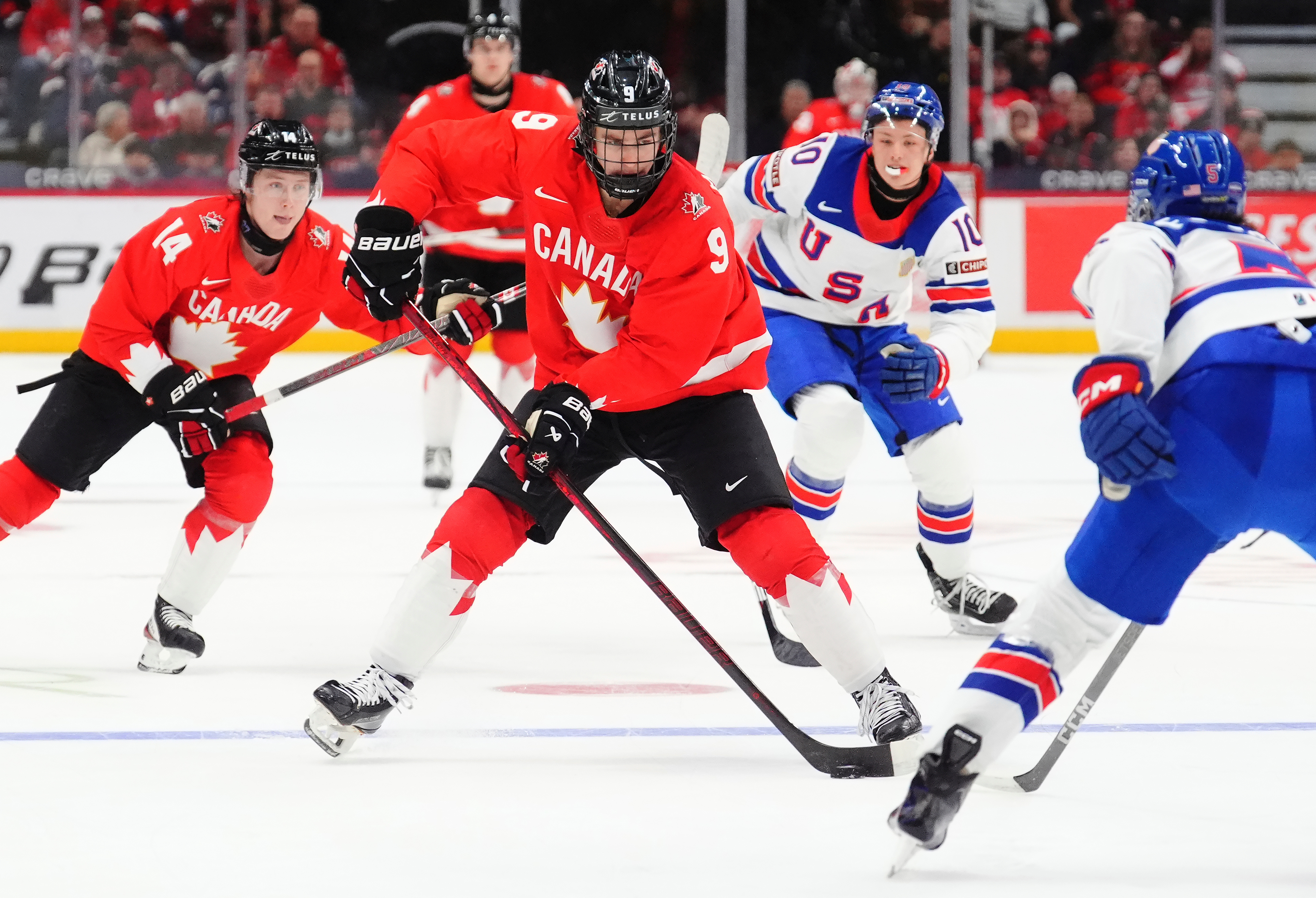FILE - Canada's Gavin McKenna (9) skates with the puck as United States' Drew Fortescue (5) defends during the second period of an IIHF World Junior Hockey Championship tournament game in Ottawa, Ontario, Dec. 31, 2024. 