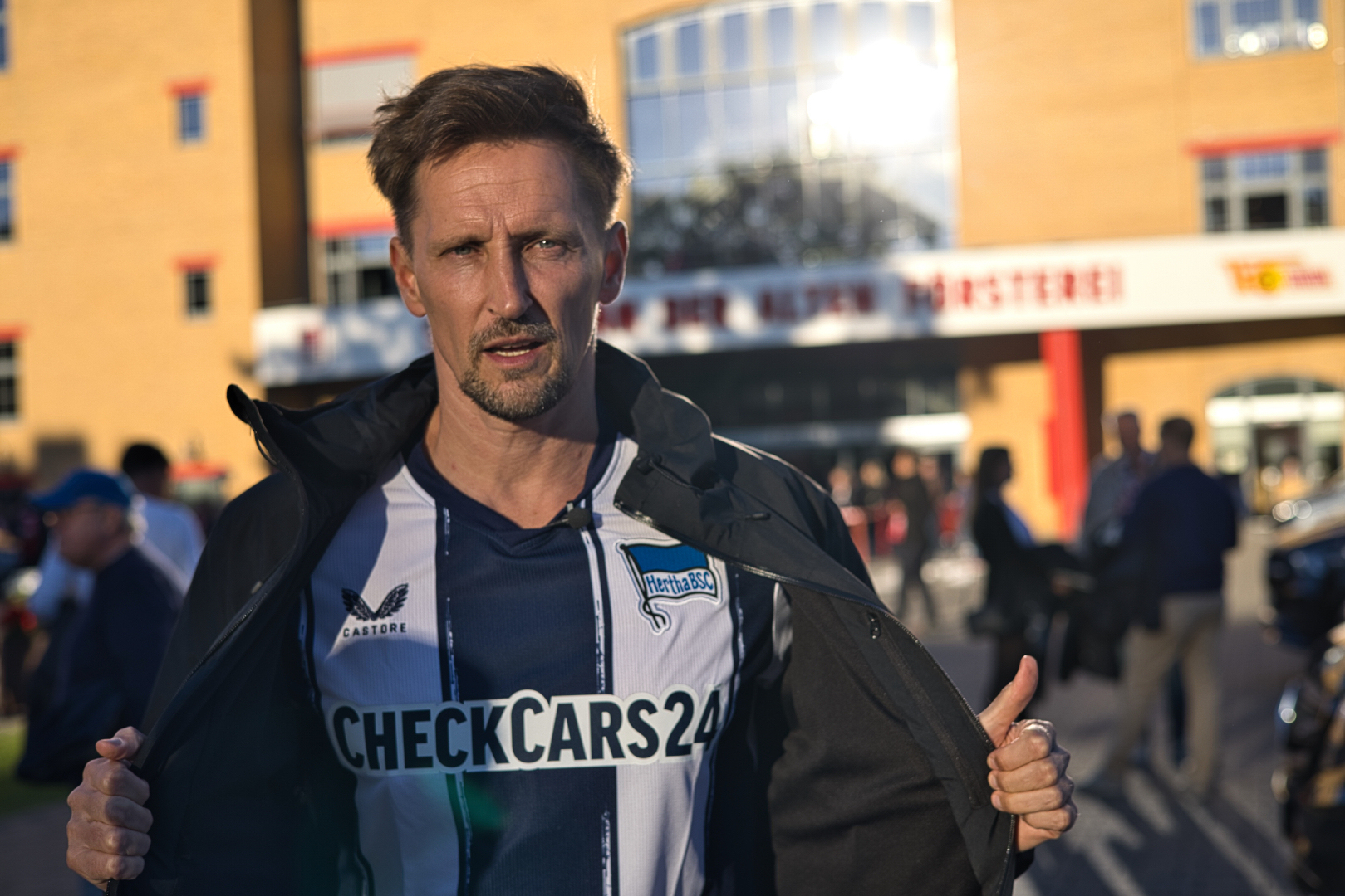 Thomas Melchior unveils a Hertha Berlin jersey before he tries to talk to Union Berlin fans about sports betting in Köpenick, Berlin, Sunday, Sept. 28, 2025.