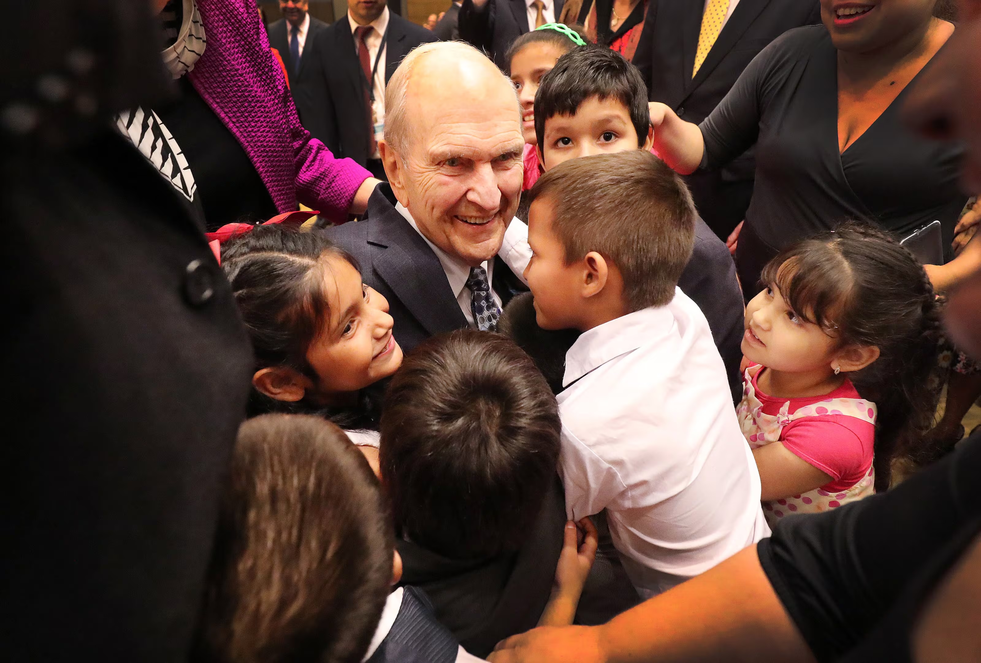 President Russell M. Nelson of The Church of Jesus Christ of Latter-day Saints hugs children after they rushed to meet him in Asuncion, Paraguay, on Monday, Oct. 22, 2018.