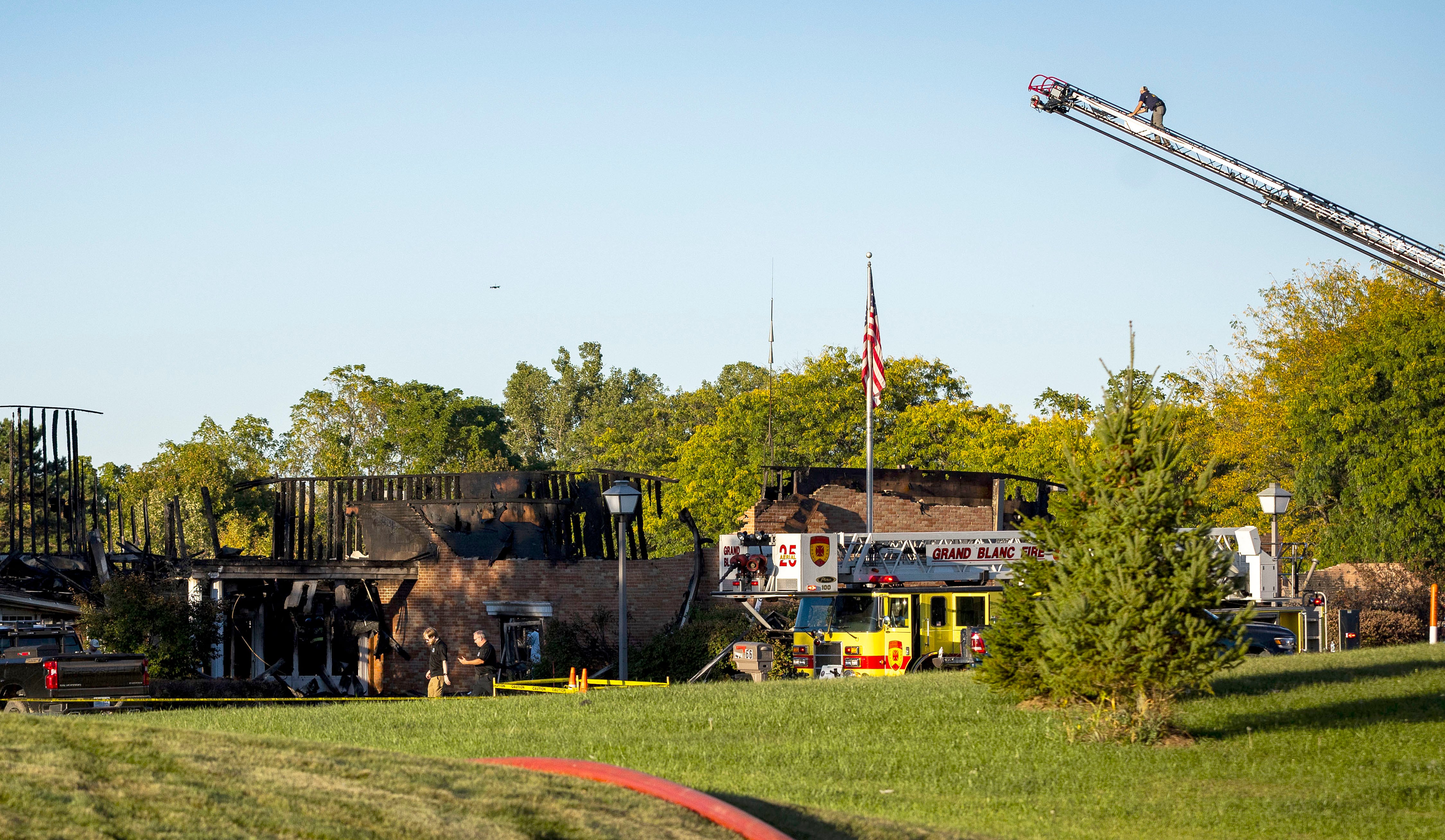 Firefighters and law enforcement work the scene surrounding the burnt structure of a meetinghouse of The Church of Jesus Christ of Latter-day Saints, where a shooting and fire happened in Grand Blanc Township, Michigan, on Sept. 28.