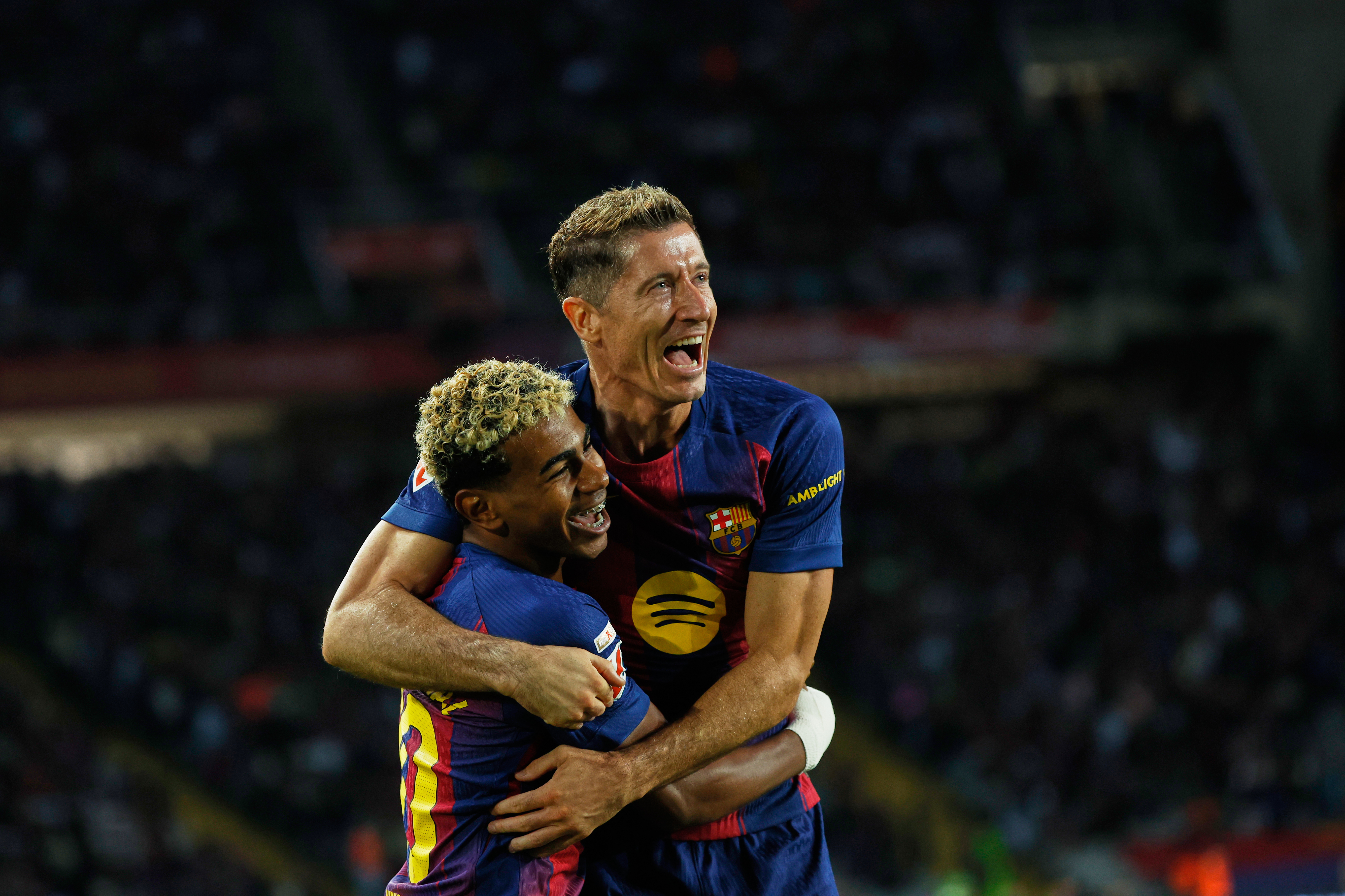 Barcelona's Robert Lewandowski, top, celebrates with Lamine Yamal scoring his side's 2nd goal during a Spanish La Liga soccer match between FC Barcelona and Real Sociedad at the Lluis Companys Olympic Stadium in Barcelona, Spain, Sunday, Sept. 28, 2025.