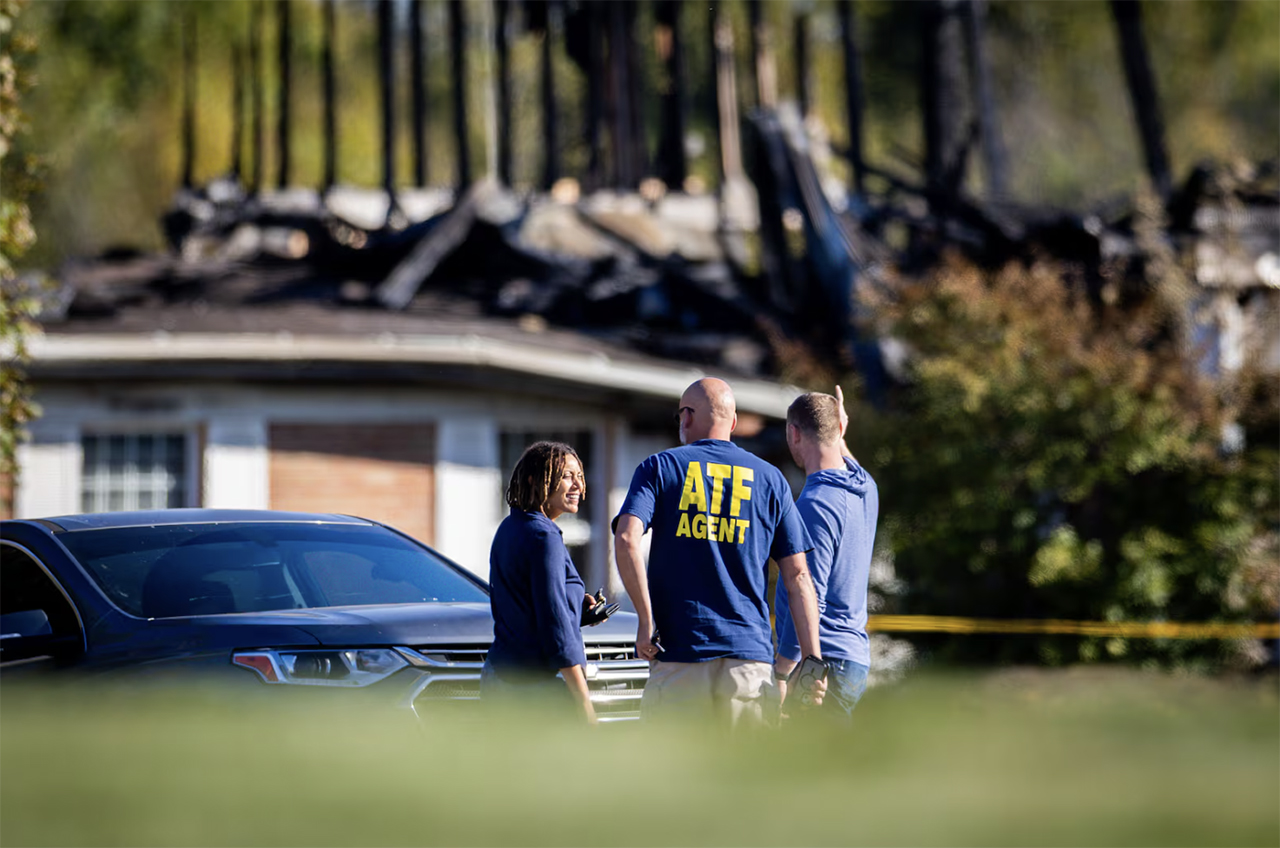 Law enforcement works the scene surrounding the burnt structure of a meetinghouse of The Church of Jesus Christ of Latter-days Saints where a shooting and fire happened on Sunday in Grand Blanc Township, Mich., on Monday.  