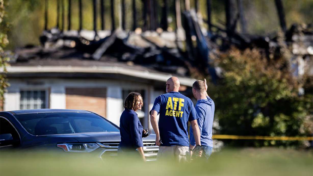 Law enforcement works the scene surrounding the burnt structure of a meetinghouse of The Church of Jesus Christ of Latter-days Saints where a shooting and fire happened on Sunday in Grand Blanc Township, Mich., on Monday.