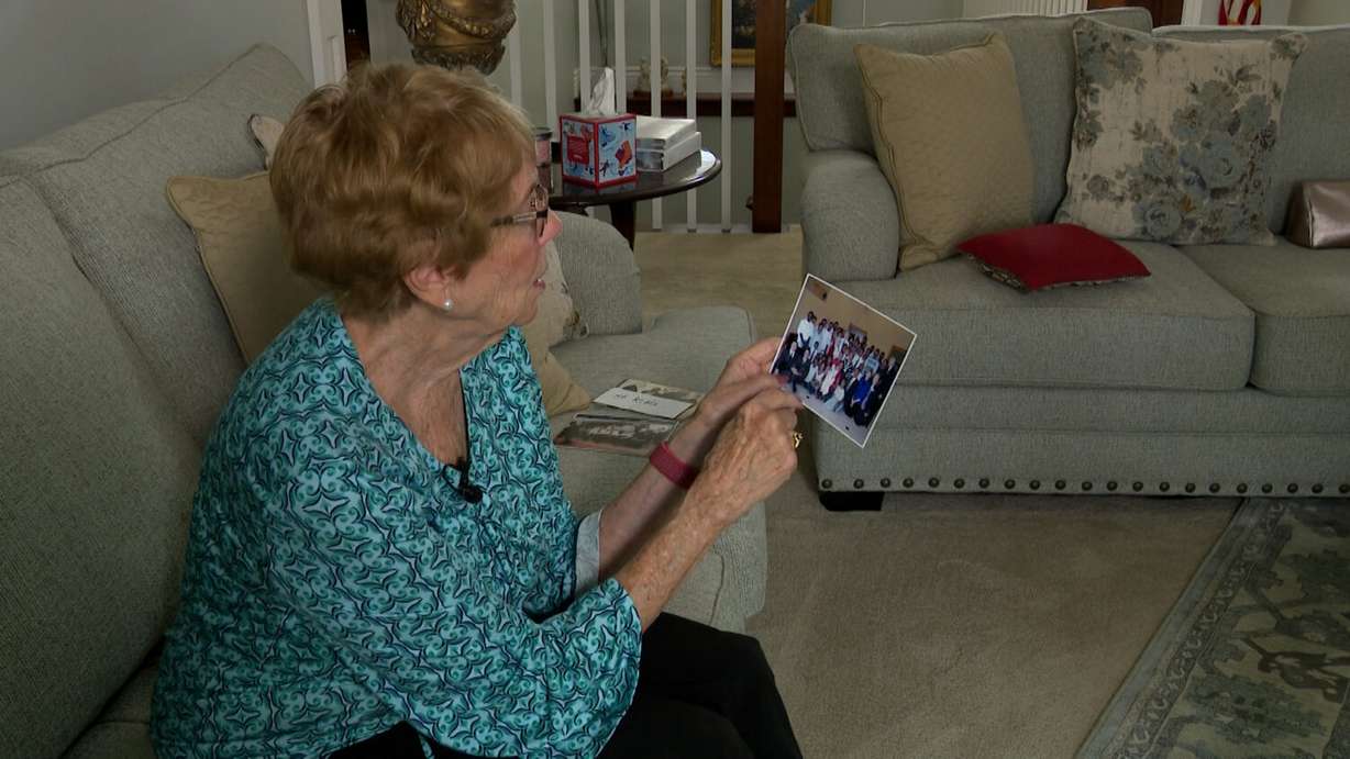 Kathleen Walker looks at photos of her father, President Gordon B. Hinckley, and then-Elder Russell M. Nelson.