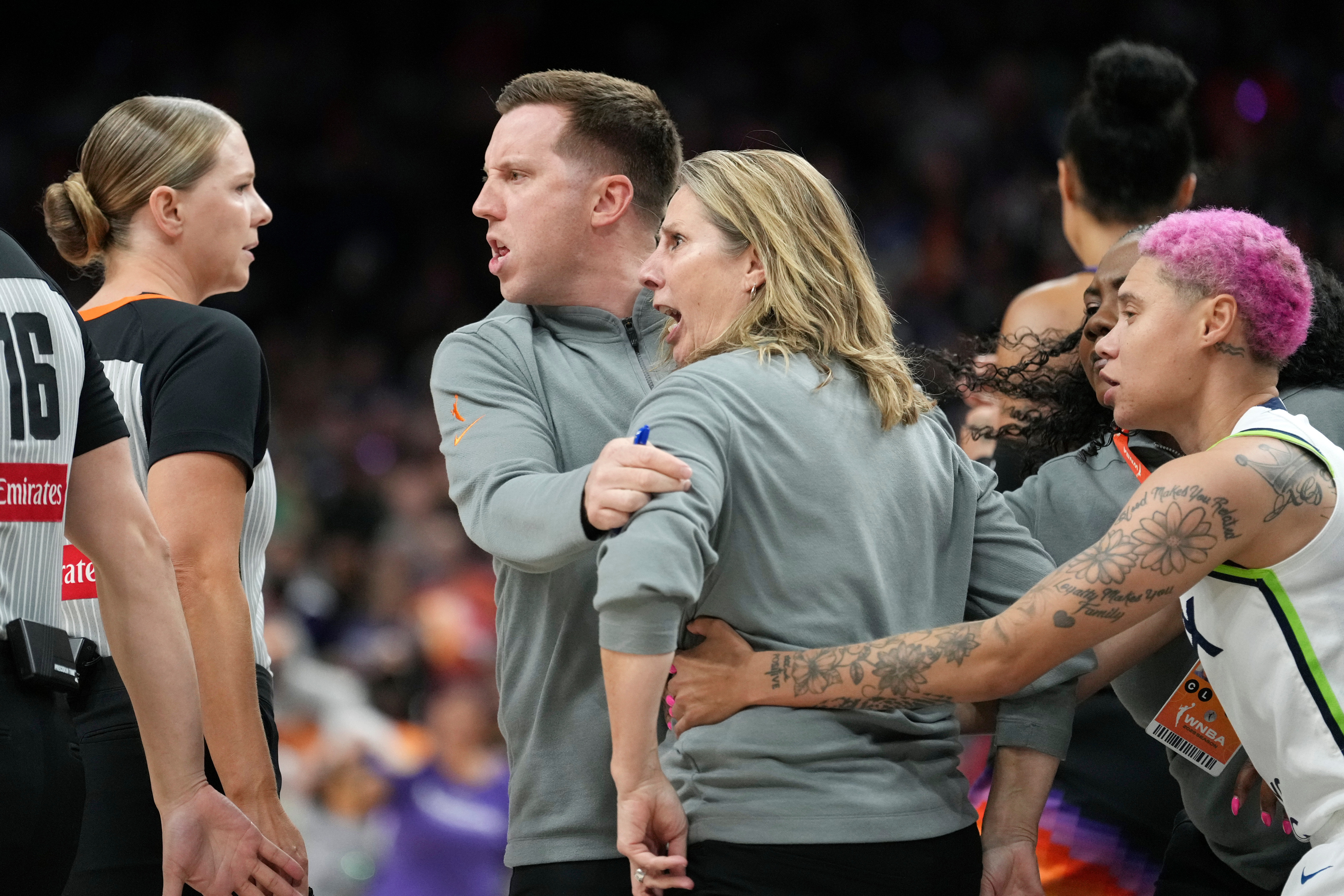 Minnesota Lynx head coach Cheryl Reeve, second from right, yells at officials as she is restrained by Lynx associate head coach Eric Thibault, center, and Lynx guard Natisha Hiedeman, right, after being ejected after earning a second technical foul during the second half of Game 3 of a WNBA basketball playoff semifinals series game against the Phoenix Mercury Friday, Sept. 26, 2025, in Phoenix. 
