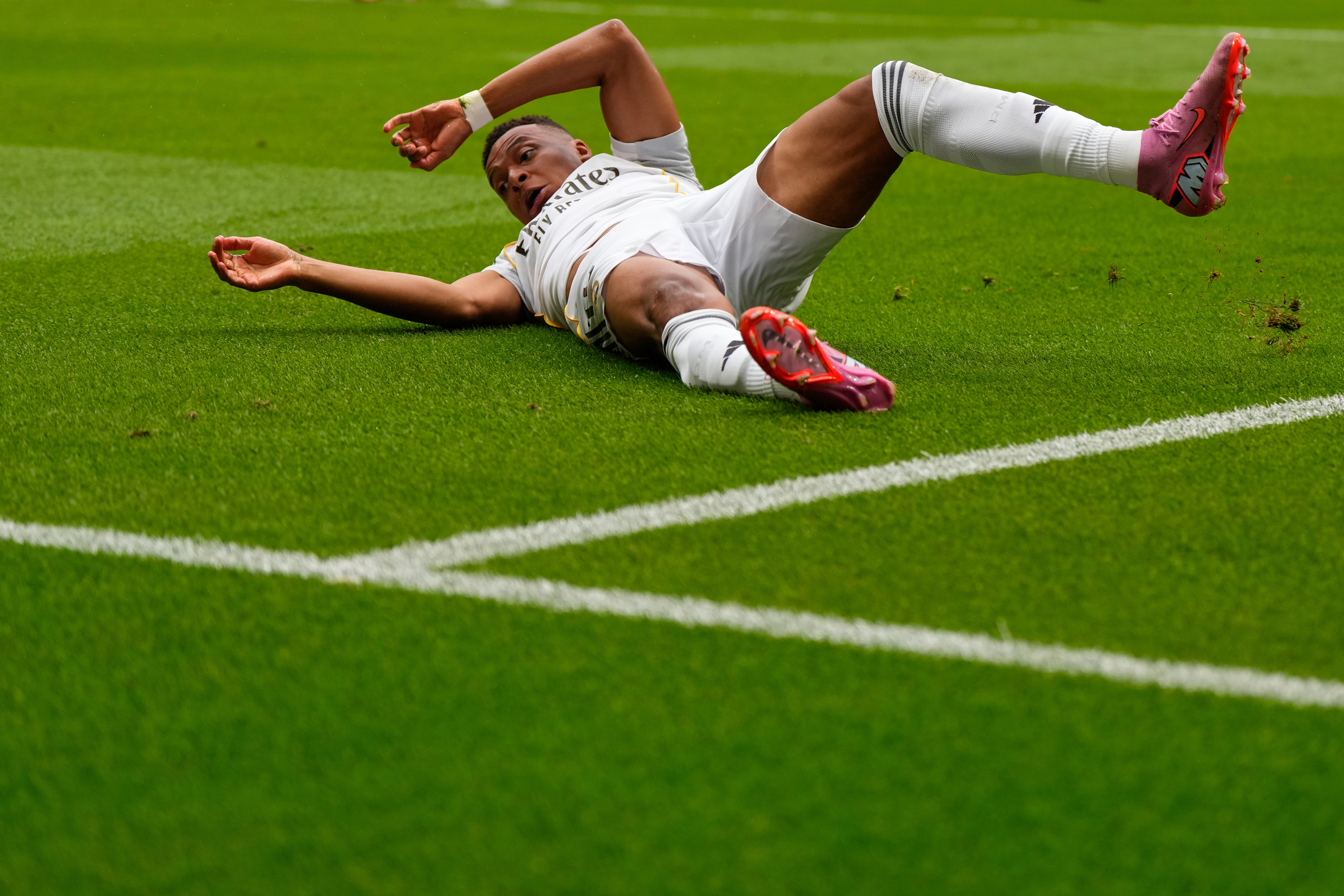 Real Madrid's Kylian Mbappe falls as he battles for the ball during the Spanish La Liga soccer match between Atletico Madrid and Real Madrid at Metropolitano stadium, in Madrid, Spain, Saturday, Sept. 27, 2025.