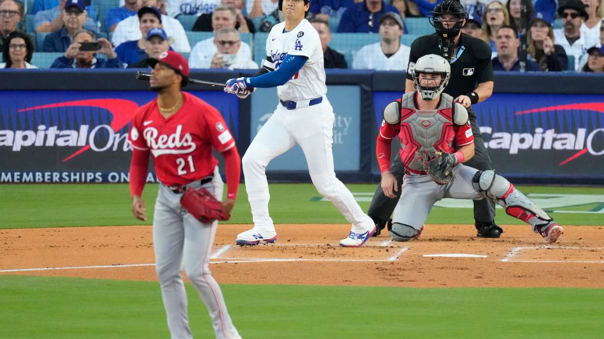 Los Angeles Dodgers' Shohei Ohtani watches his solo home run off Cincinnati Reds starting pitcher Hunter Greene (21) during the first inning in Game 1 of the National League Wild Card baseball playoff series Tuesday, Sept. 30, 2025, in Los Angeles.
