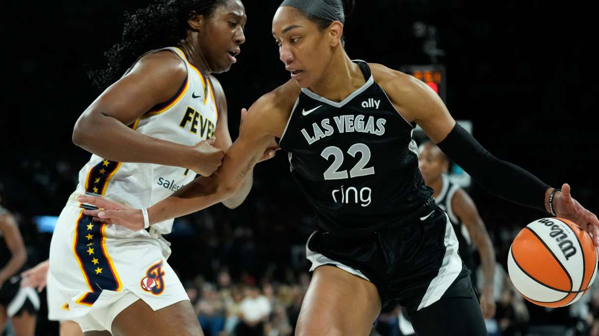 Las Vegas Aces center A'ja Wilson (22) drives against Indiana Fever forward Aliyah Boston (7) during the first half of Game 5 of a WNBA basketball playoff semifinals series Tuesday, Sept. 30, 2025, in Las Vegas.