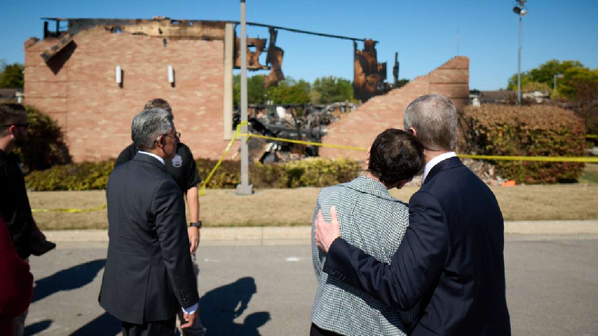 Elder David A. Bednar hugs his wife, Sister Susan Bednar, while visiting the burned wreckage at the scene of a fire and shooting at a meetinghouse of The Church of Jesus Christ of Latter-day Saints in Grand Blanc Township, Michigan, on Tuesday.