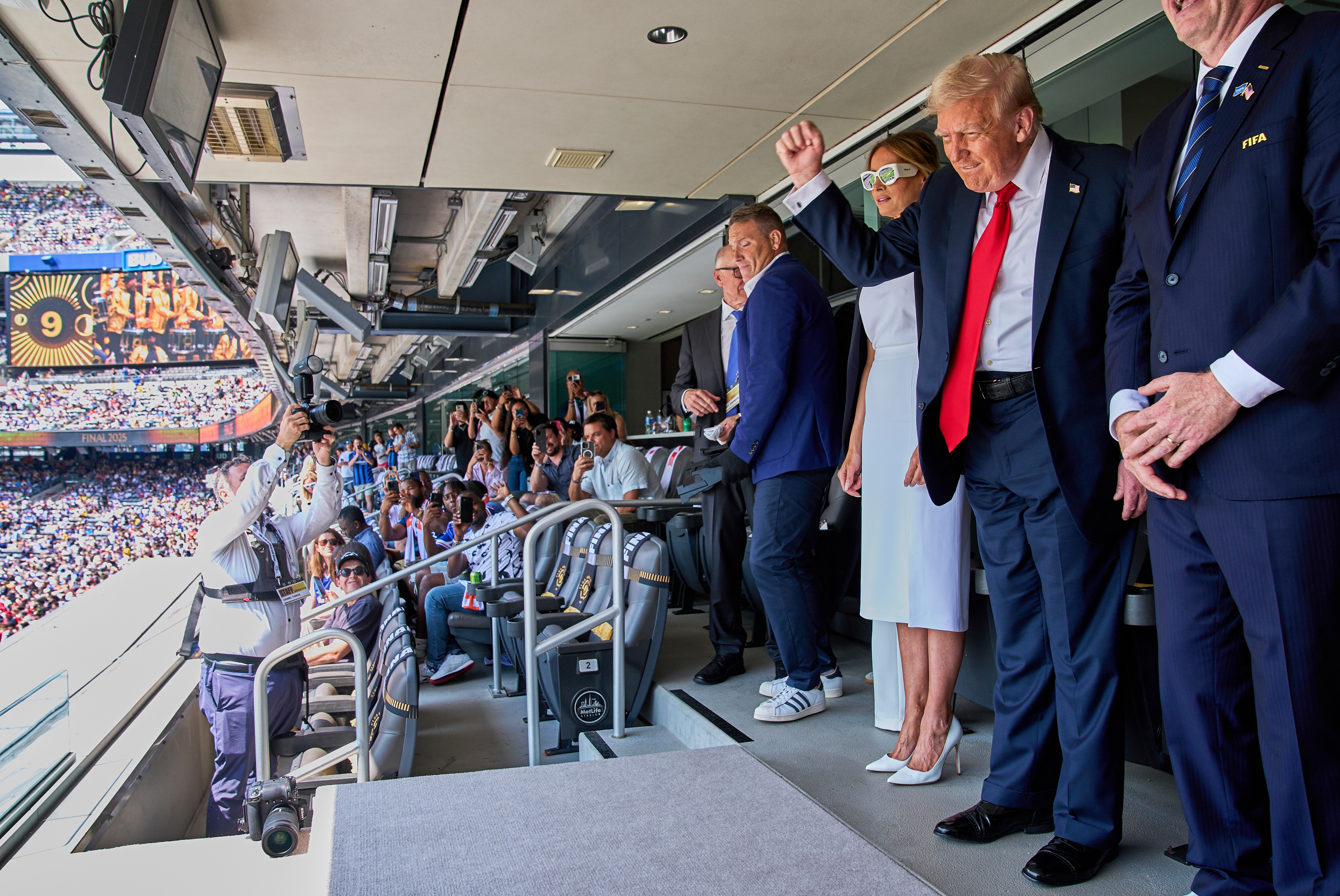 FILE - President Donald Trump, from right, pumps his fist as he and first lady Melania Trump look to the crowd while attending the Club World Cup final soccer match, at MetLife Stadium in East Rutherford, N.J., July 13, 2025. 