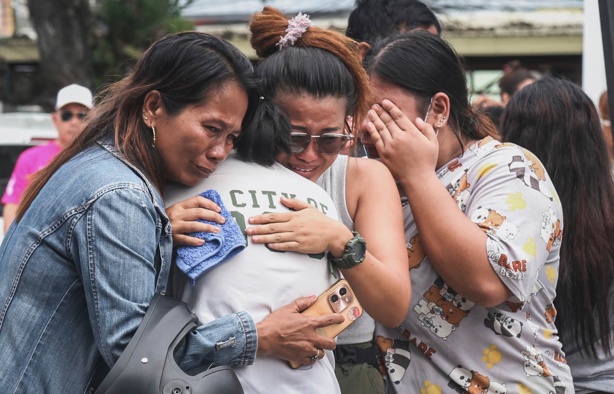 People grieve after identifying the body of a victim outside Cebu Provincial Hospital in Bogo, Philippines, Wednesday. The government is weighing whether to ask for foreign aid,