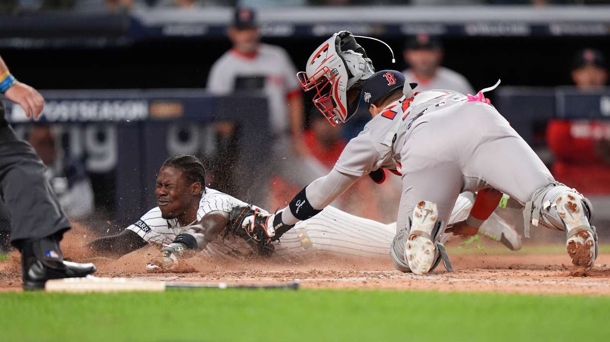New York Yankees Jazz Chisholm Jr. slides safely into home plate ahead of the tag from Boston Red Sox catcher Carlos Narváez (75) during the eighth inning of Game 2 of an American League wild-card baseball playoff series, Wednesday, Oct. 1, 2025, in New York.