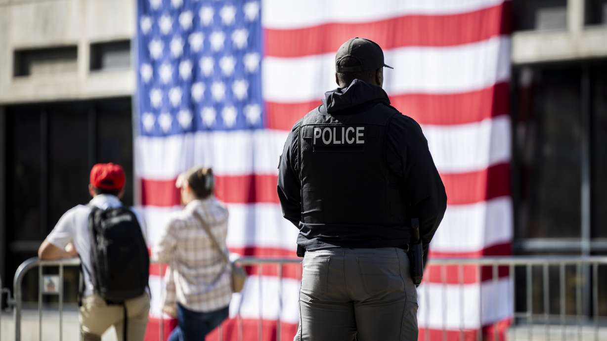 An officer stands near an American flag displayed at Utah Valley University on Sept. 17. The Utah Board of Higher Education voted Thursday to establish a task force to examine campus safety across Utah's public higher education institutions.